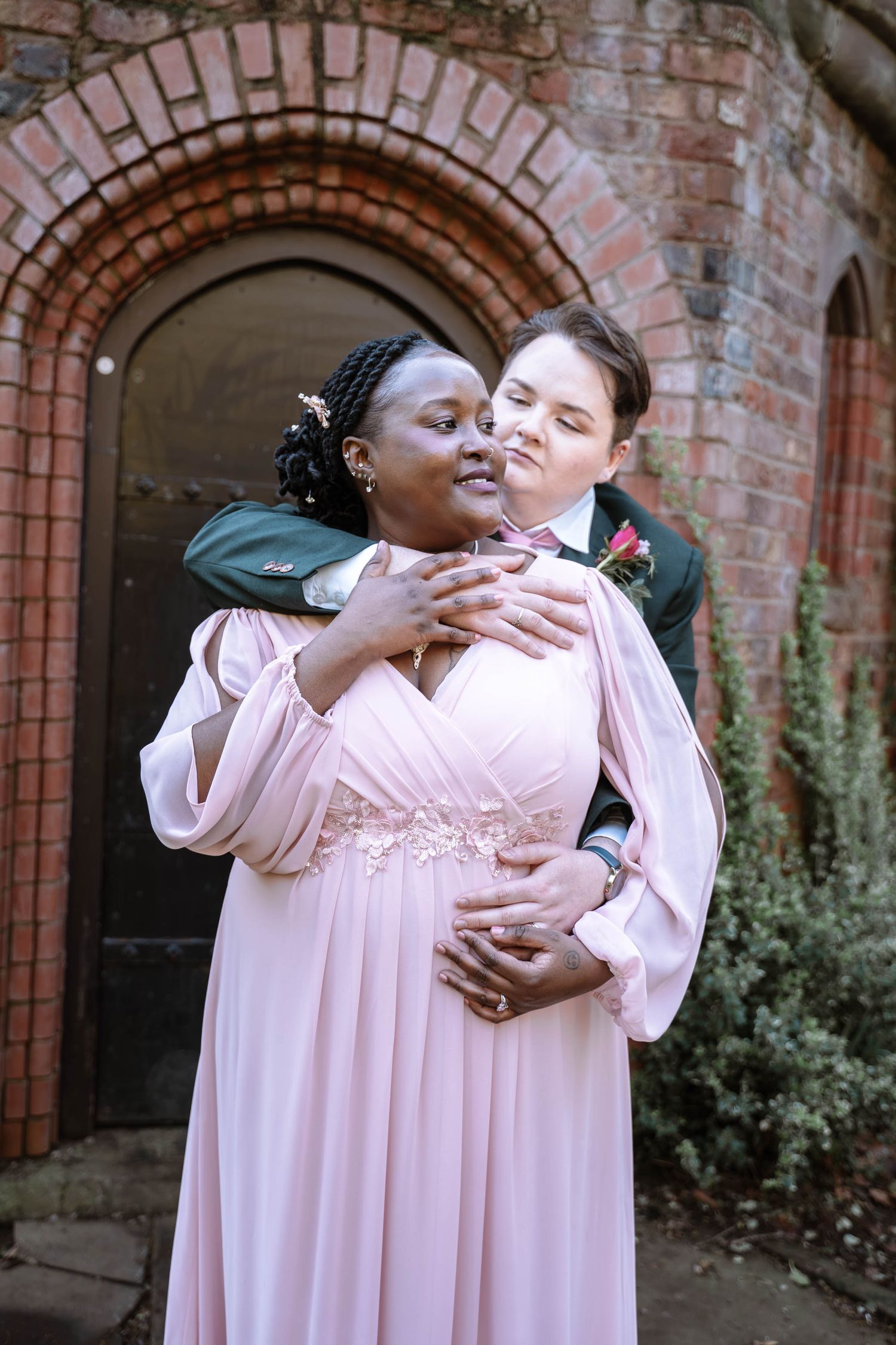 Couple embracing under brick archway during Manchester registry office wedding