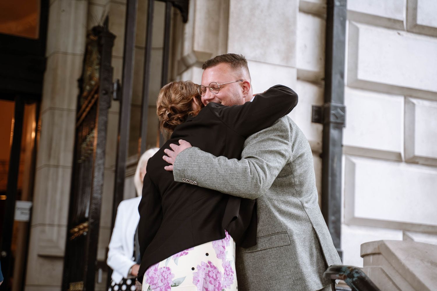 Newlywed groom hugging guest outside Belfast City Hall