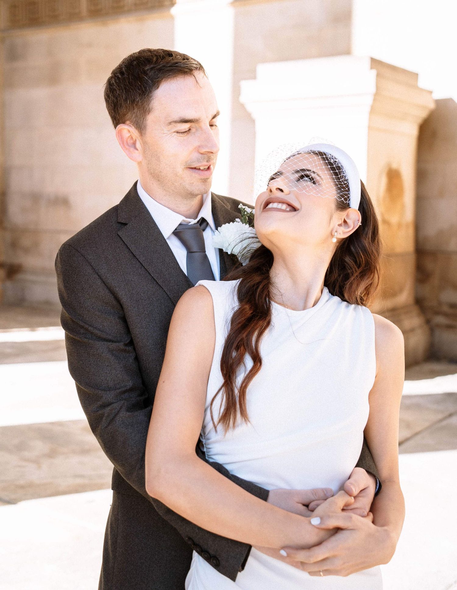 Couple standing beneath the columns of St George Hall Liverpool during their wedding portraits.