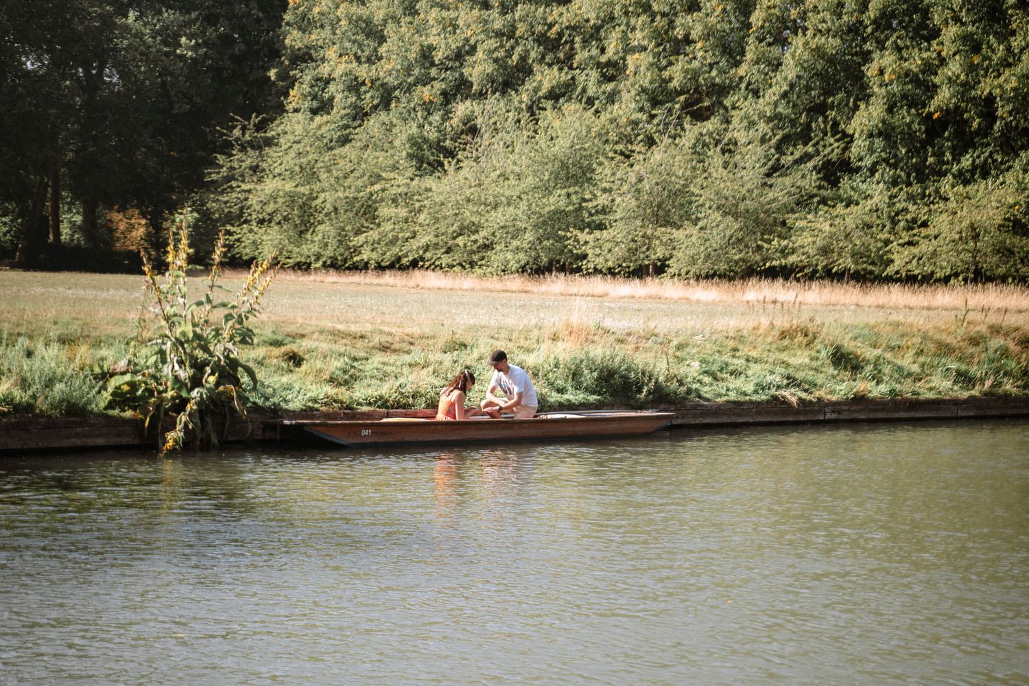 Couple sitting together in a punt on the River Cam during a Cambridge proposal
