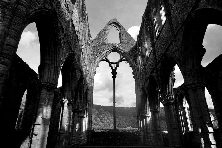Interior view of Tintern Abbey with tall gothic arches in black and white
