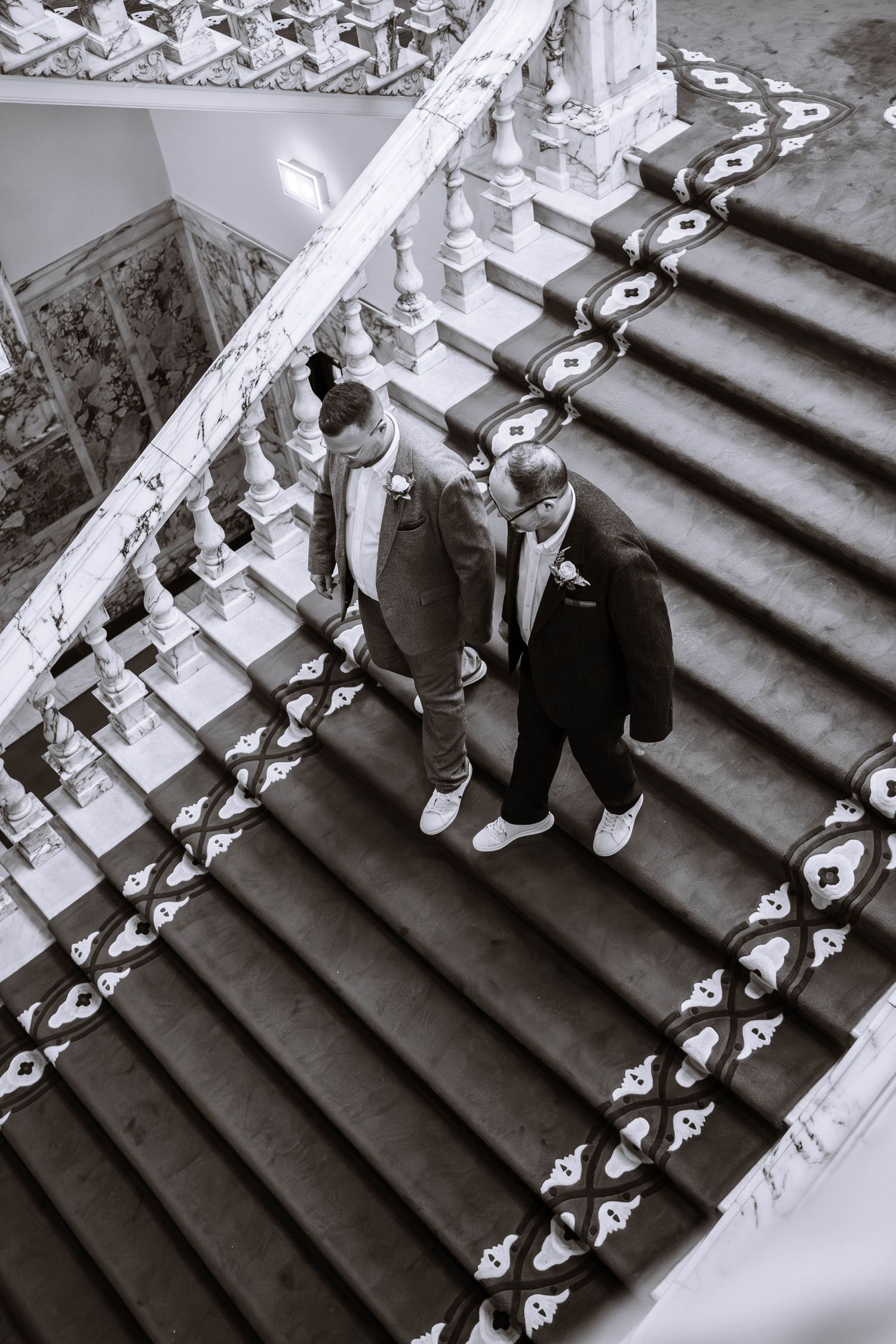 Newlywed couple walking down the staircase inside Belfast City Hall