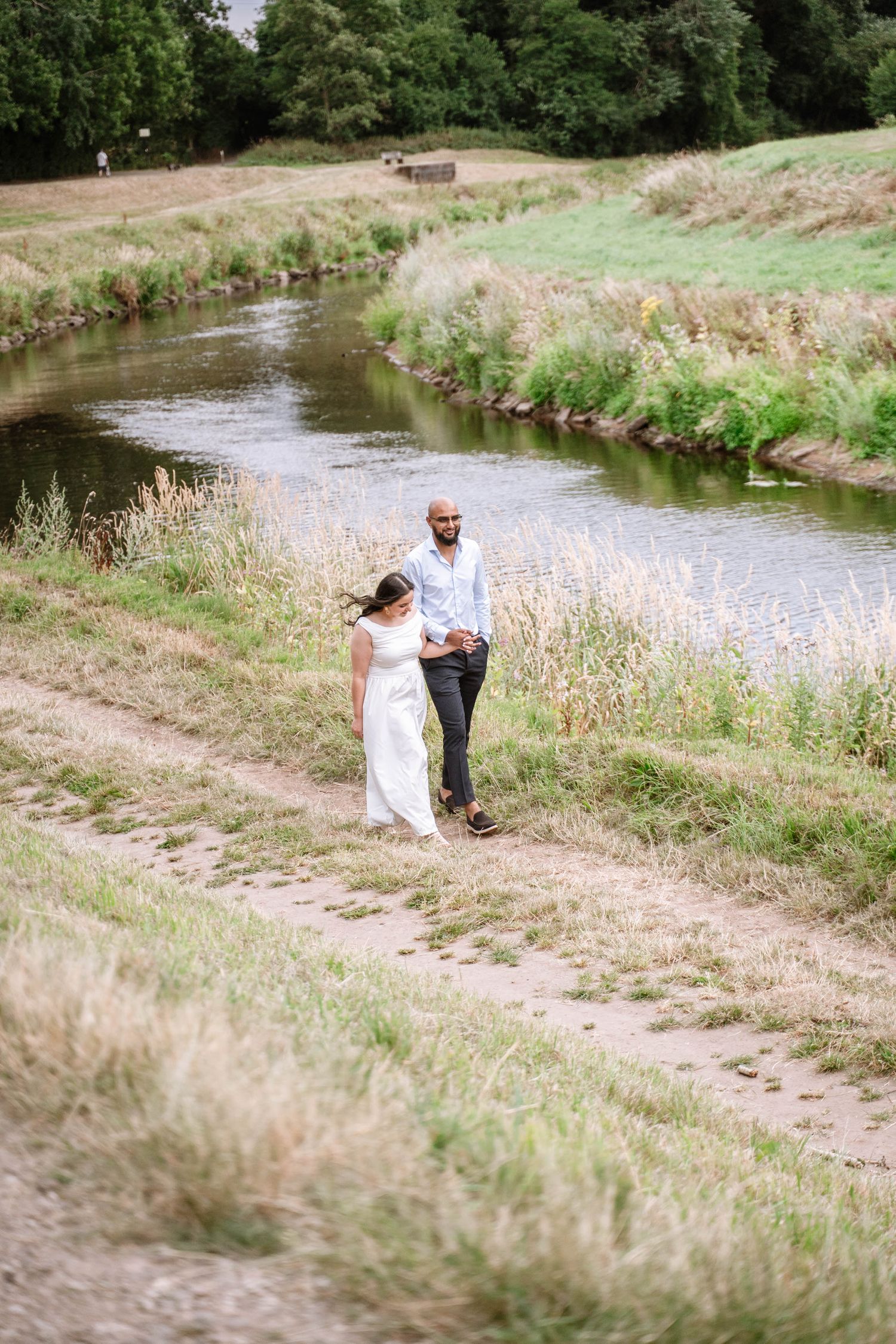 Couple walking beside the water at Fletcher Moss Park in Manchester