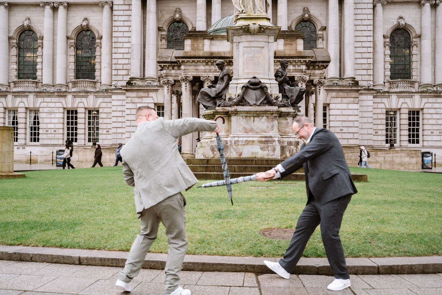 Two grooms playfighting outside Belfast City Hall