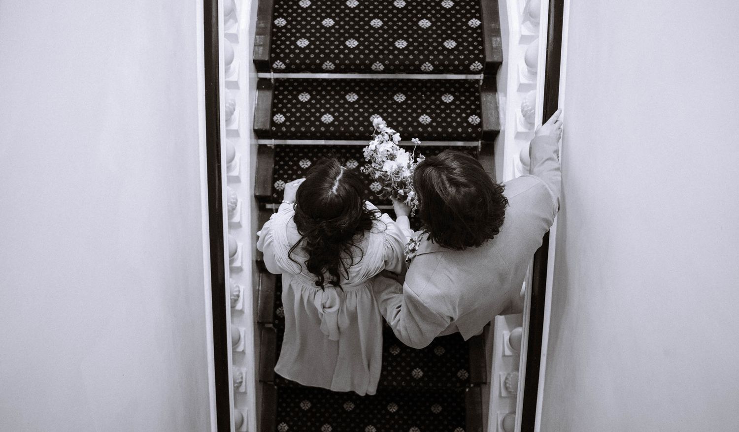 Overhead view of couple walking upstairs during wedding reception at Trafalgar Tavern