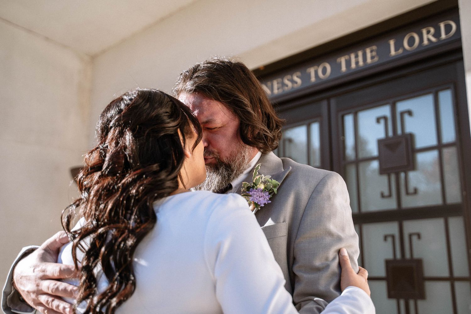 Couple embracing outside temple doors during LDS wedding in London