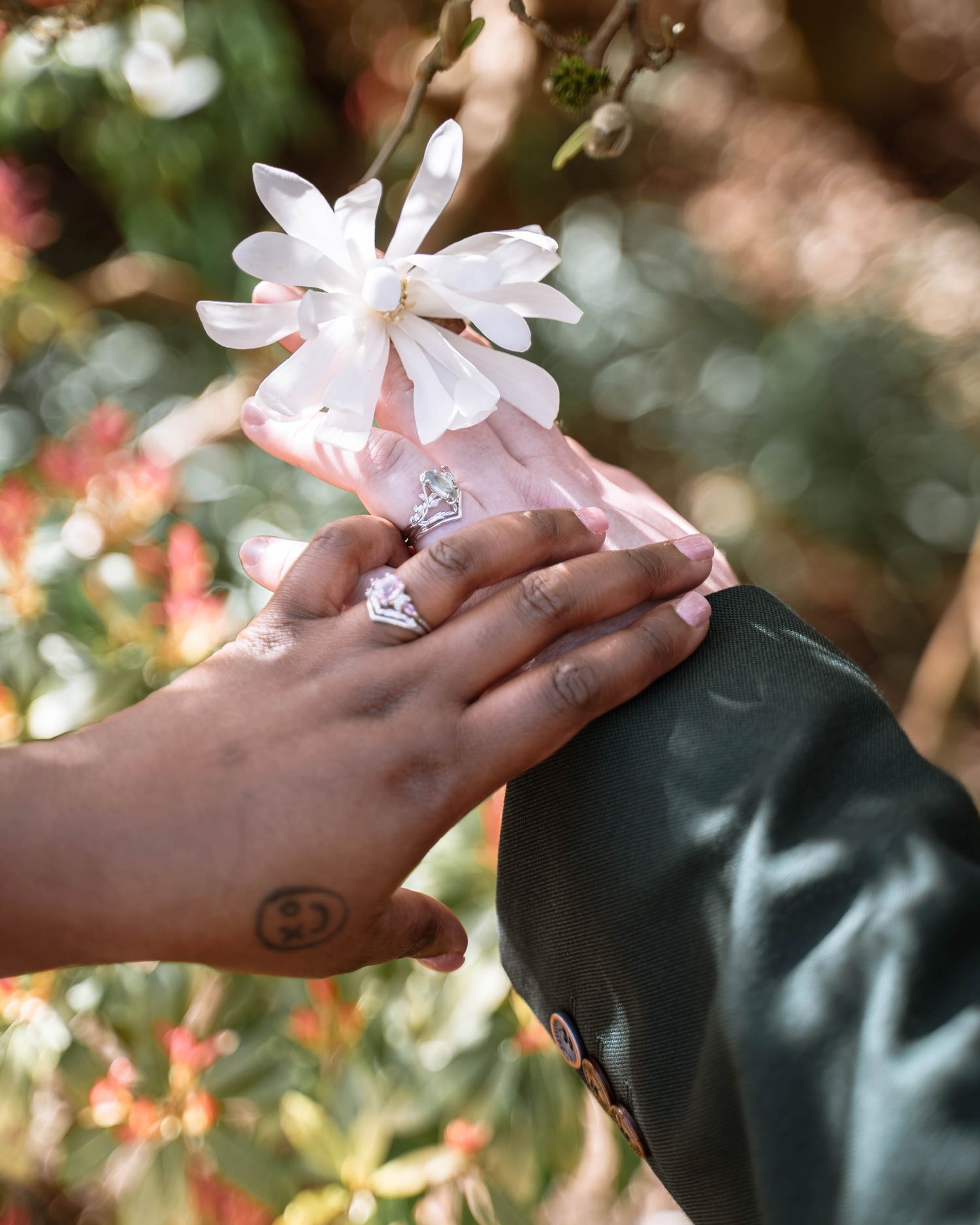 Couple holding hands with flowers during LGBTQ wedding in Manchester registry setting