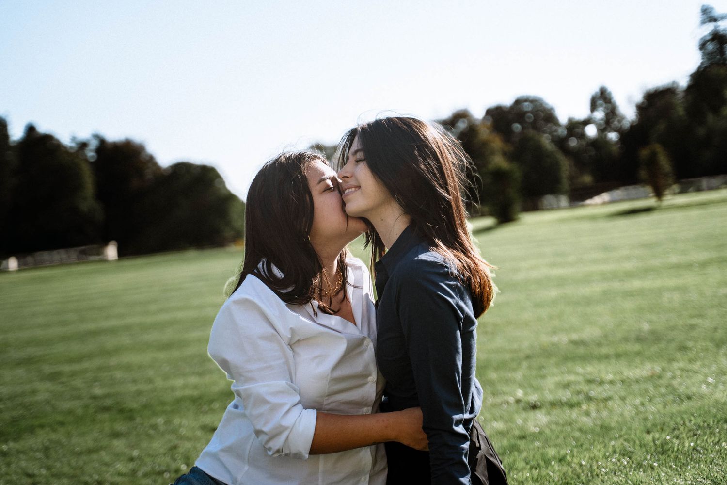 Queer couple in Cardiff kissing in dyffryn garden on sunny day