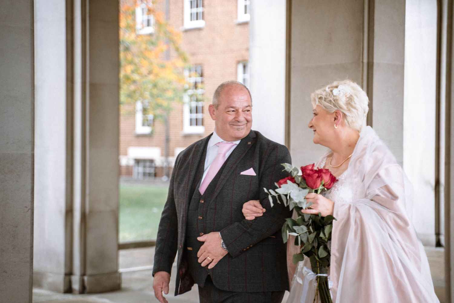 London wedding photography couple walking together under archway classic elegant city wedding portrait UK