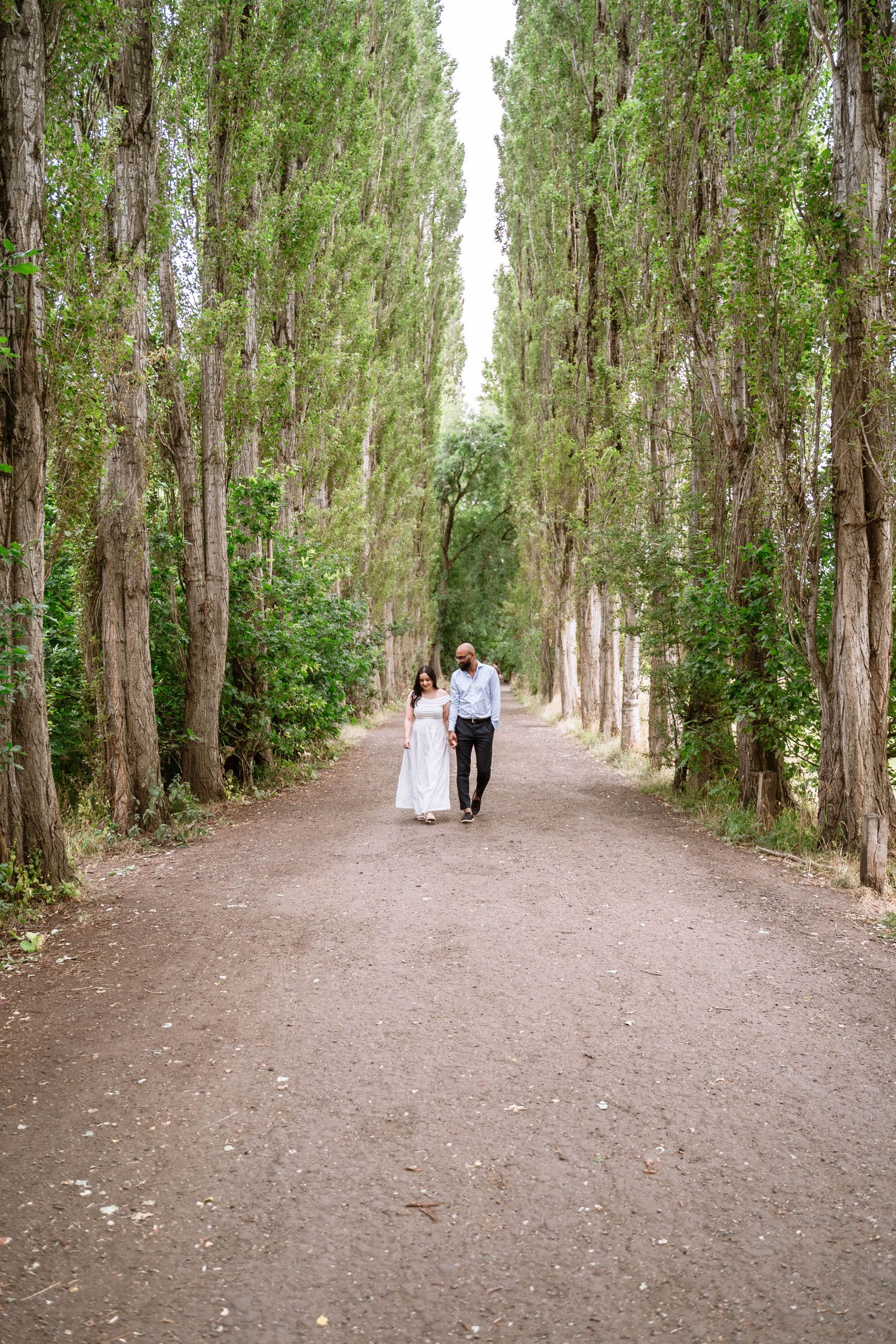Couple standing together on a woodland path at Fletcher Moss Park