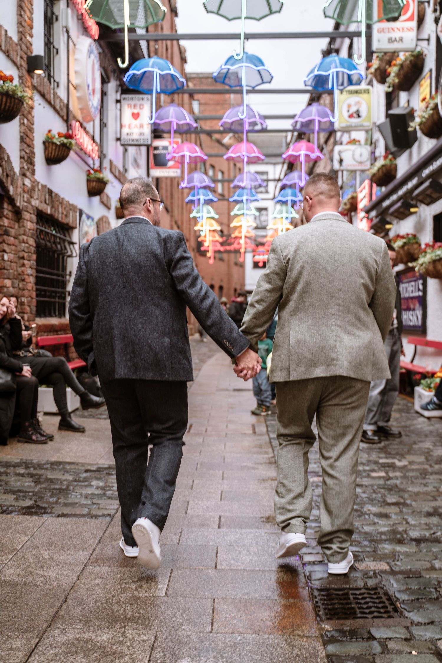 Newlywed couple walking through Belfast City Hall after an LGBTQ+ wedding ceremony