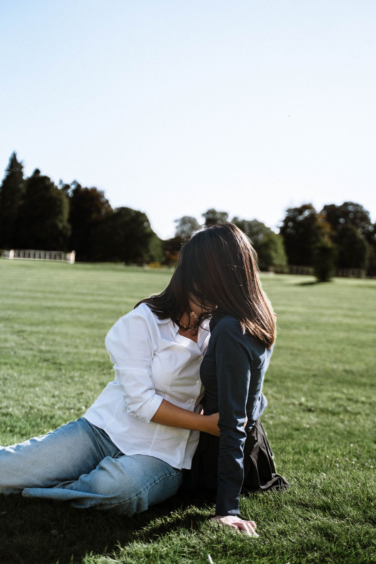 Couple sitting on grass together during Cardiff proposal shoot