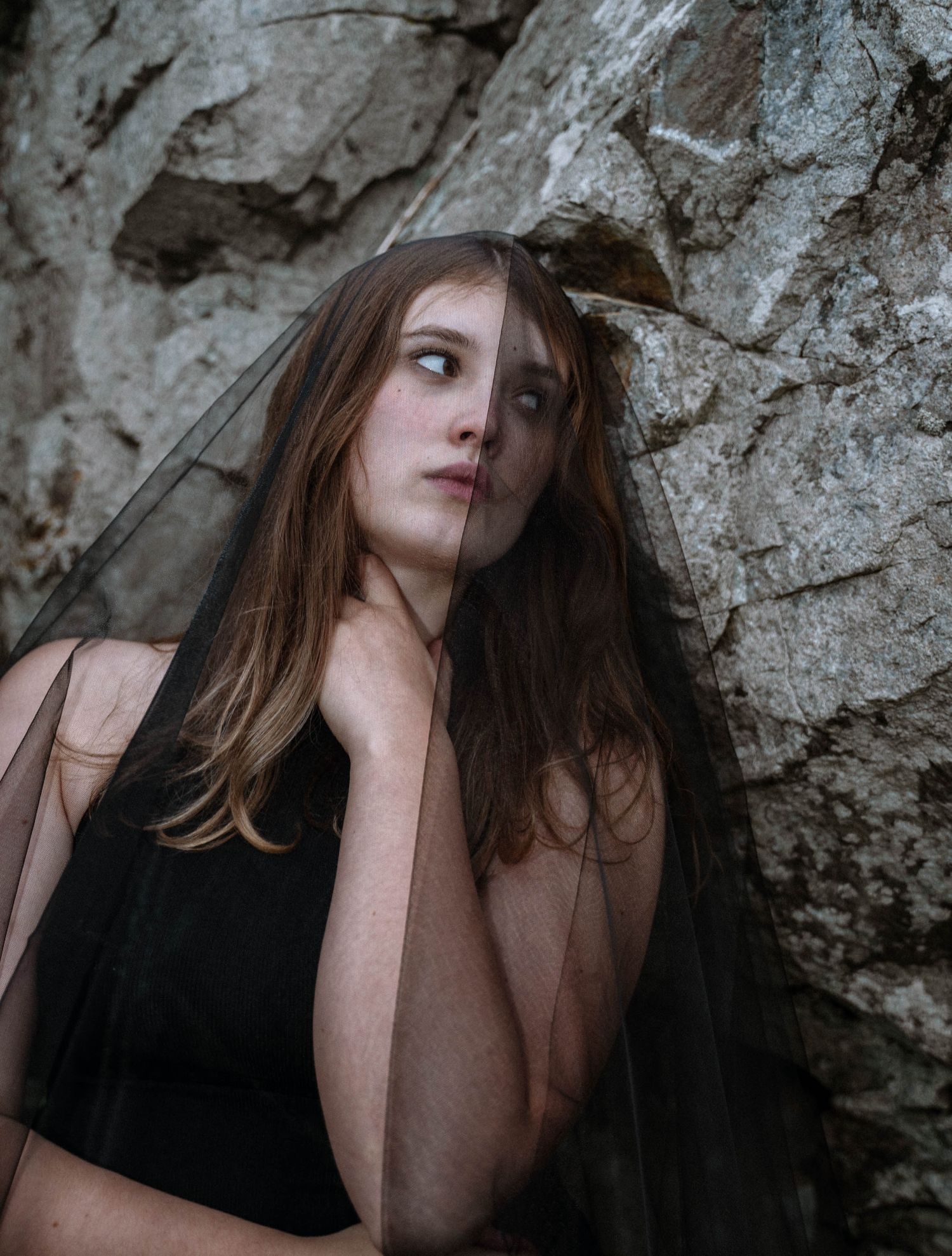 Close up portrait of bride against rock wall in Cornwall gothic shoot