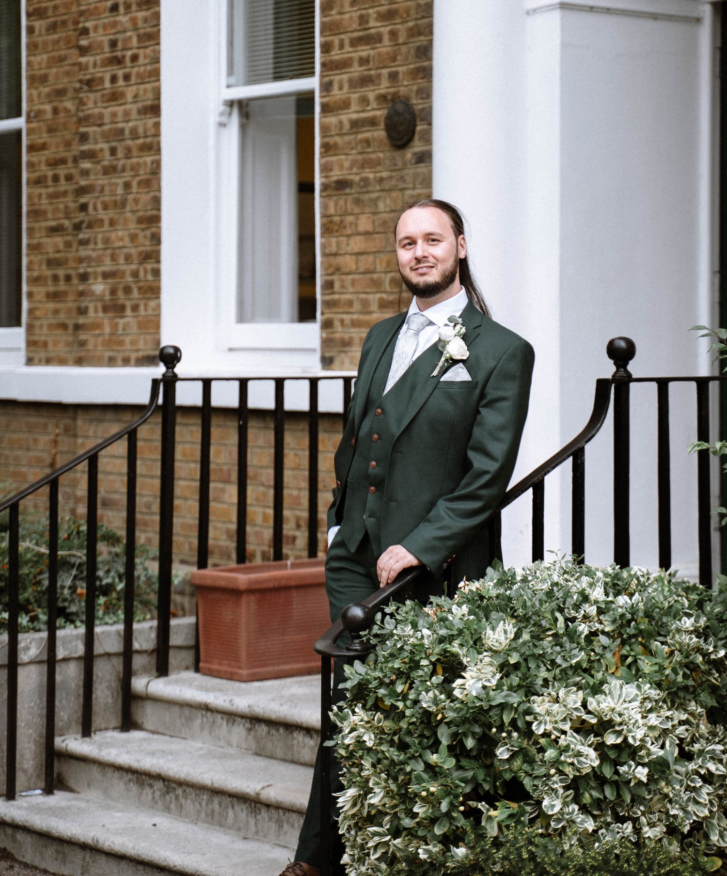 Groom portrait standing outside building during Enfield registry wedding