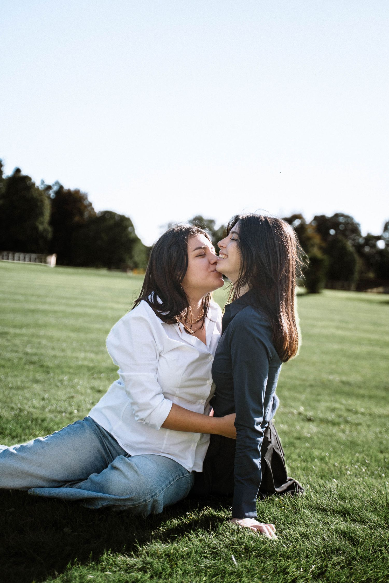 Couple kissing on grass field during Cardiff proposal shoot