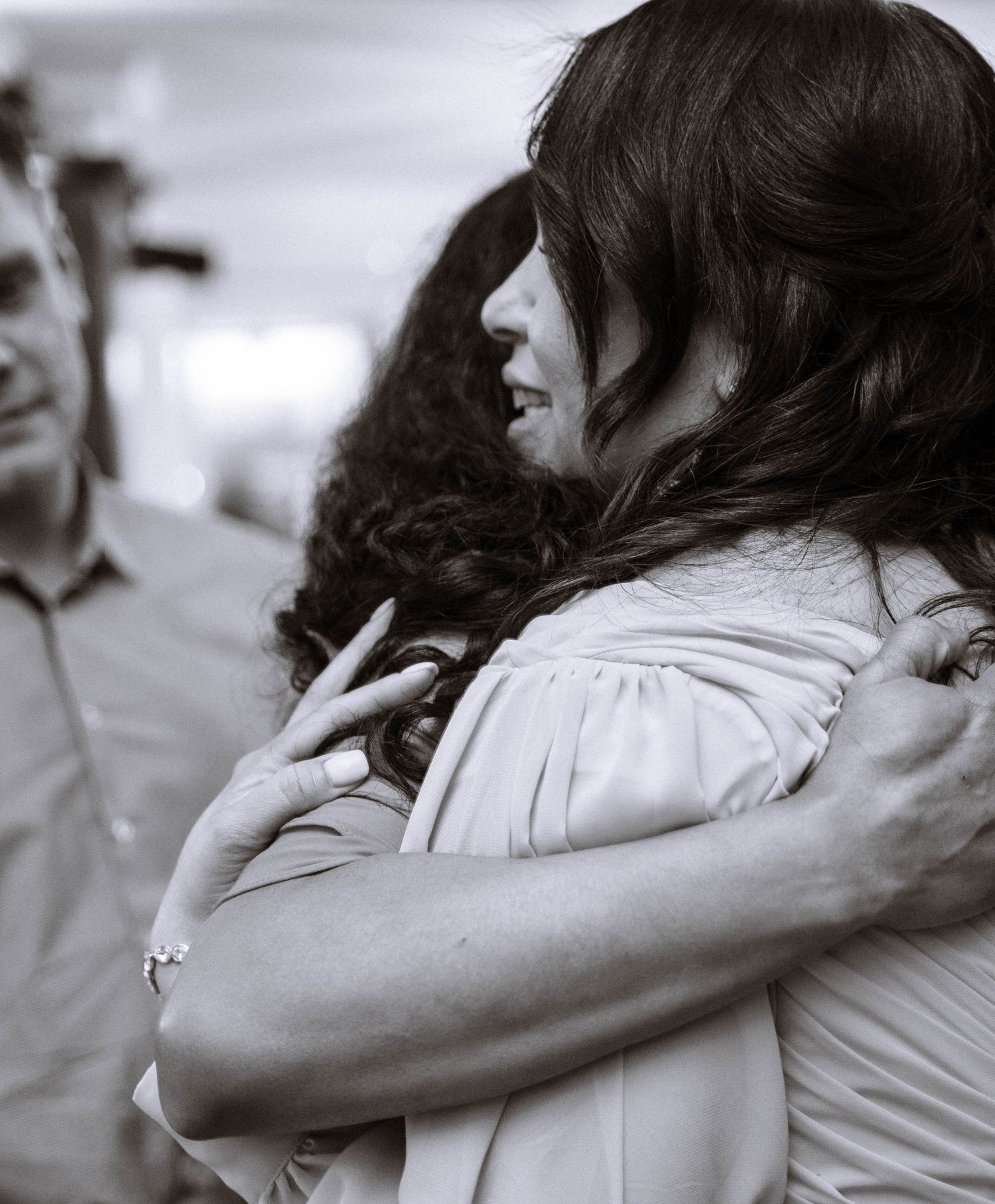 Guest hugging bride during wedding reception in black and white at Trafalgar Tavern