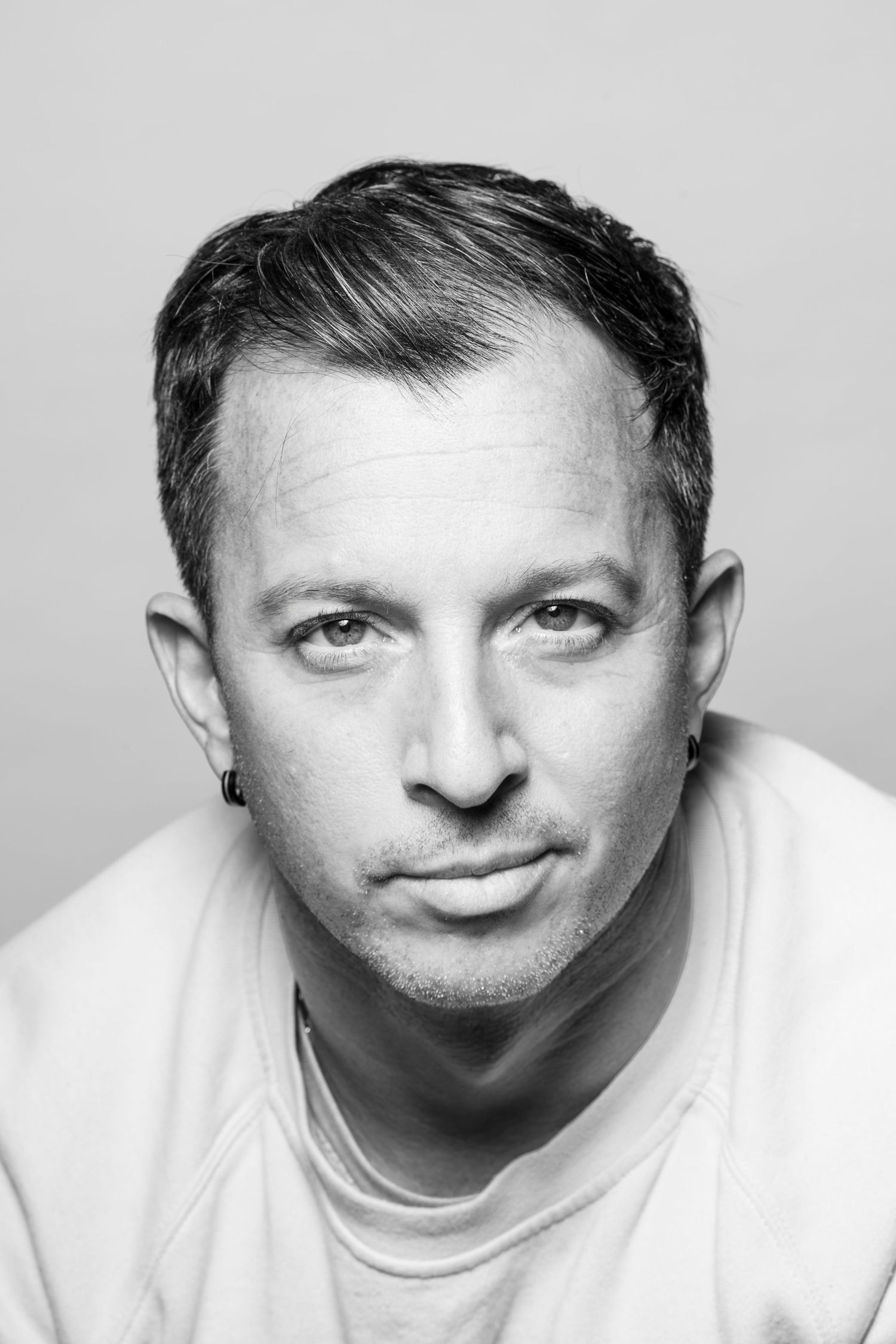 High contrast black and white portrait with direct gaze to camera.