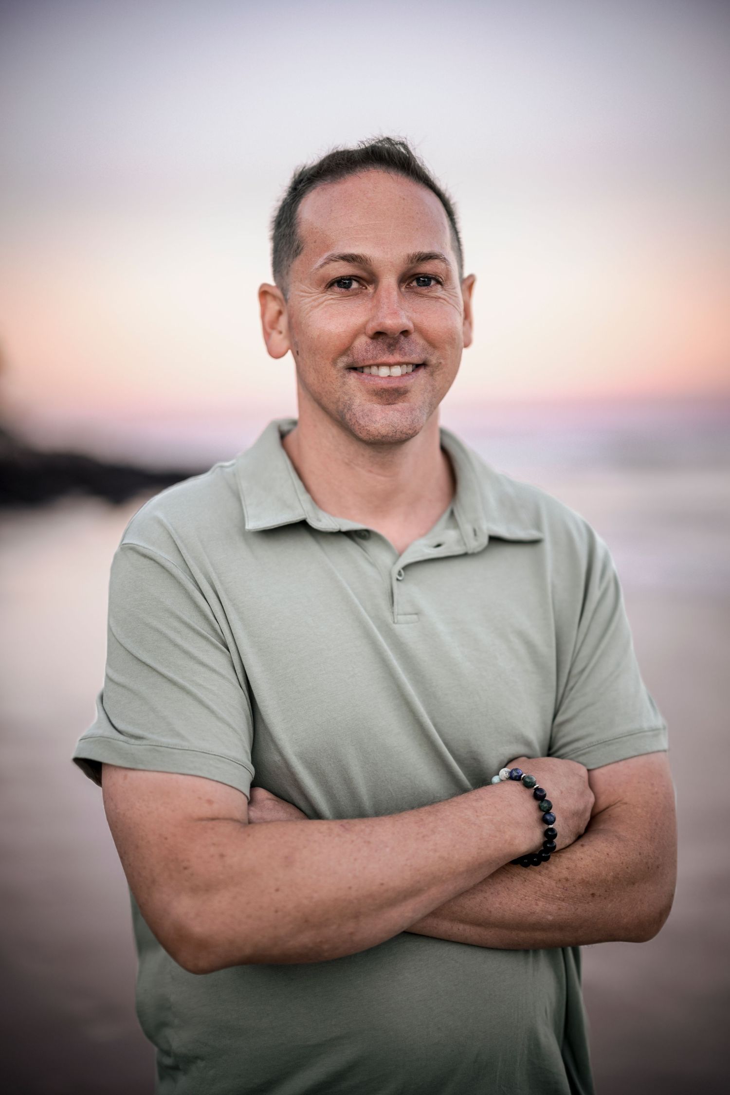 Portrait against sunset sky wearing light colored polo shirt.