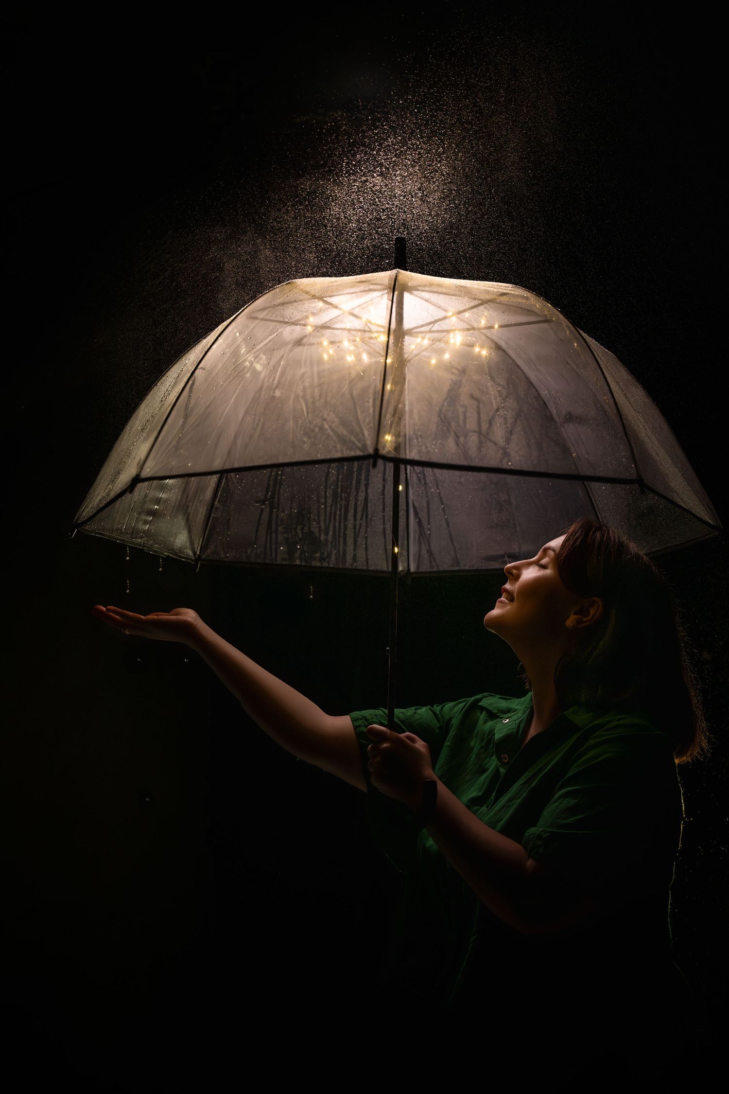 Artistic shot of someone holding a clear umbrella with magical lighting effects.
