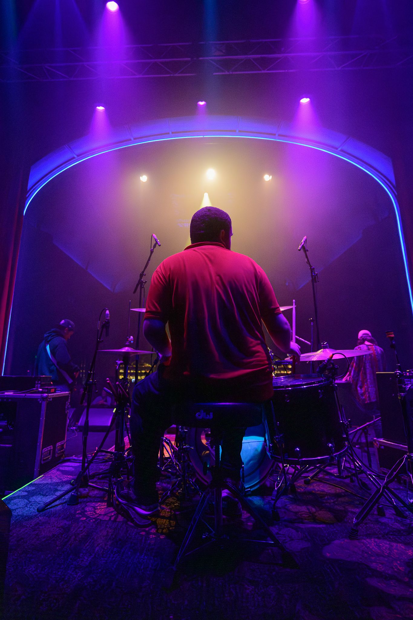Concert stage setup illuminated with purple and blue lighting creating an atmospheric ambiance.
