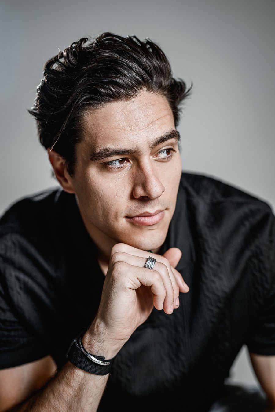 Close-up headshots showing contemplative expressions against a minimalist gray backdrop.