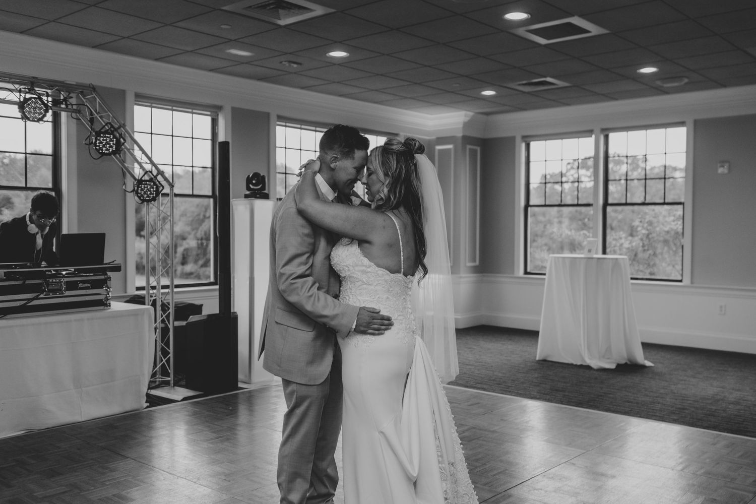 Black and white photo series showing a couple dancing together in an empty studio with large windows and mirrors.
