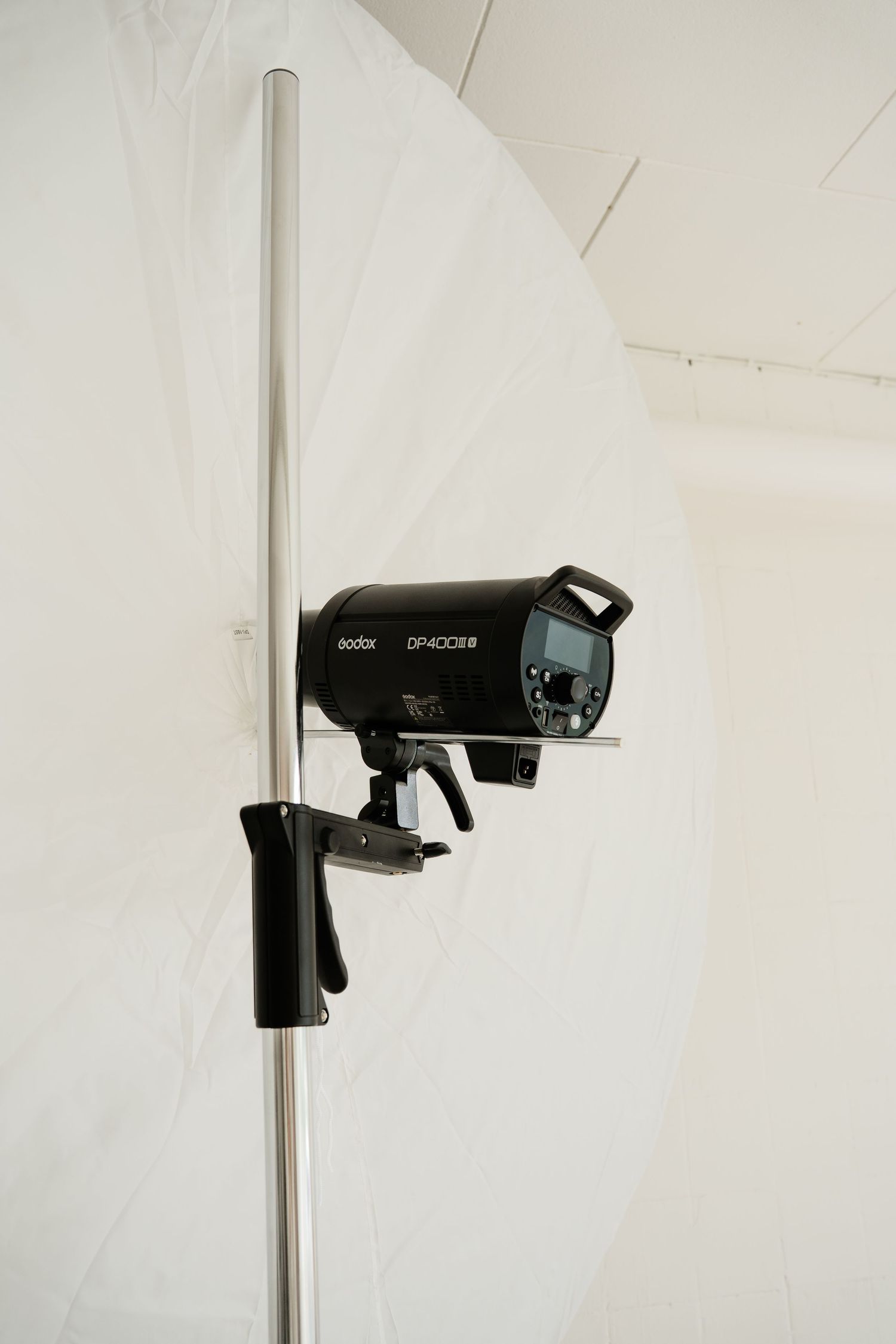 Godox DP400II studio flash strobe mounted on a light stand against a white backdrop.