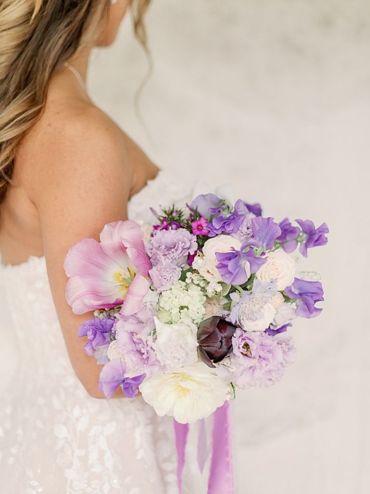Beautiful purple and white wedding bouquet with sweet peas and mixed flowers.