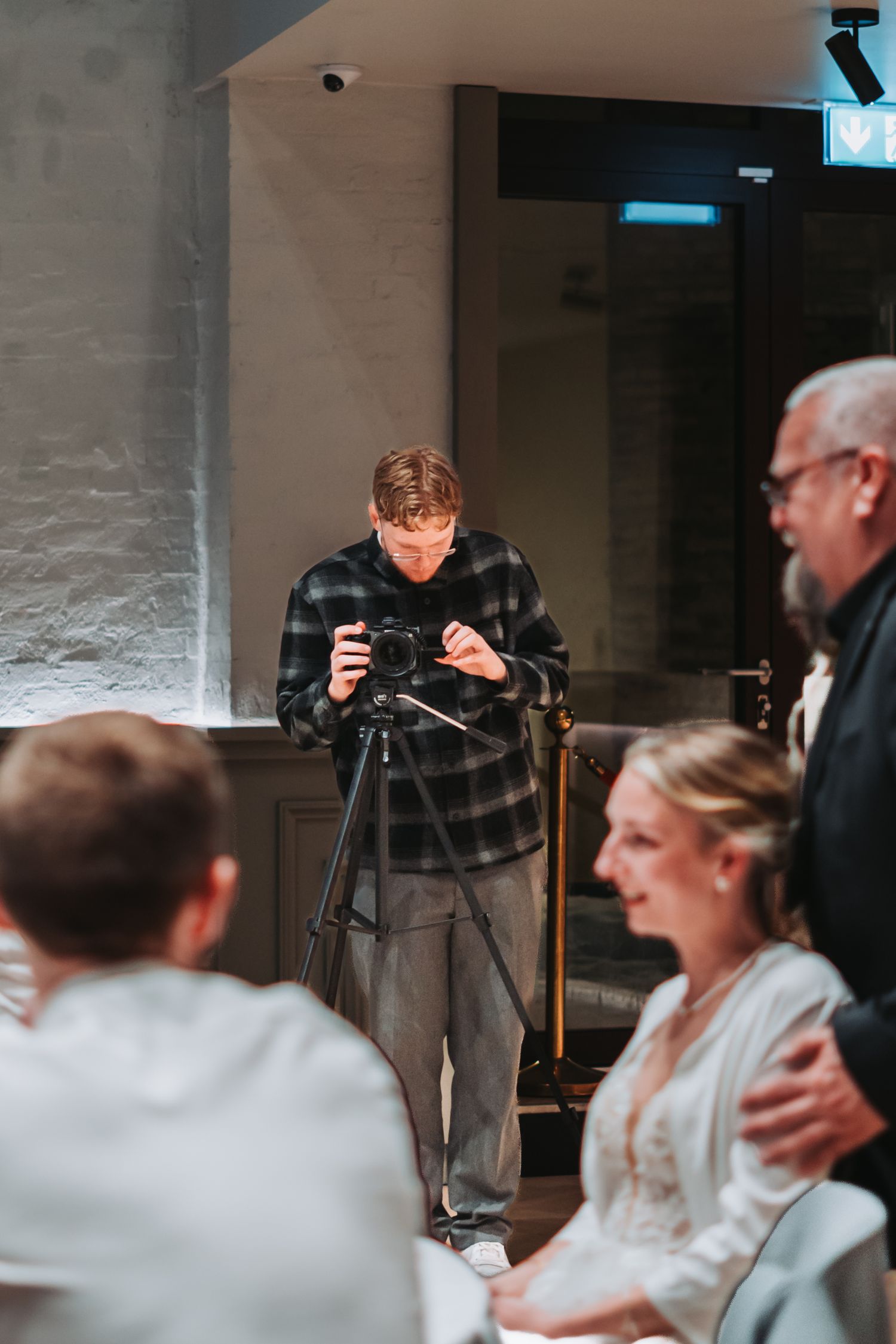 Indoor event photography session with camera equipment and guests in background.