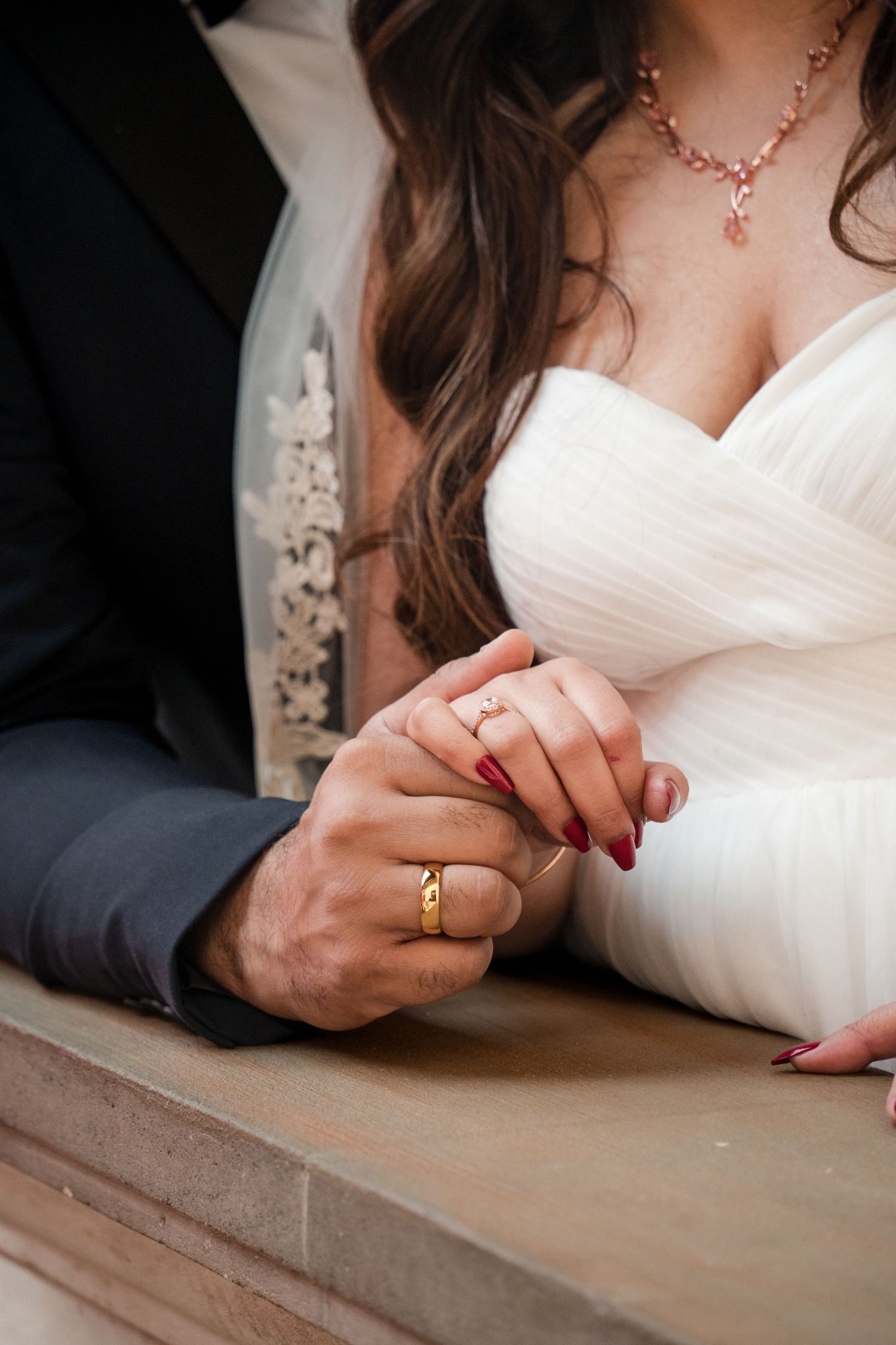 Close-up of wedding rings being exchanged during ceremony.