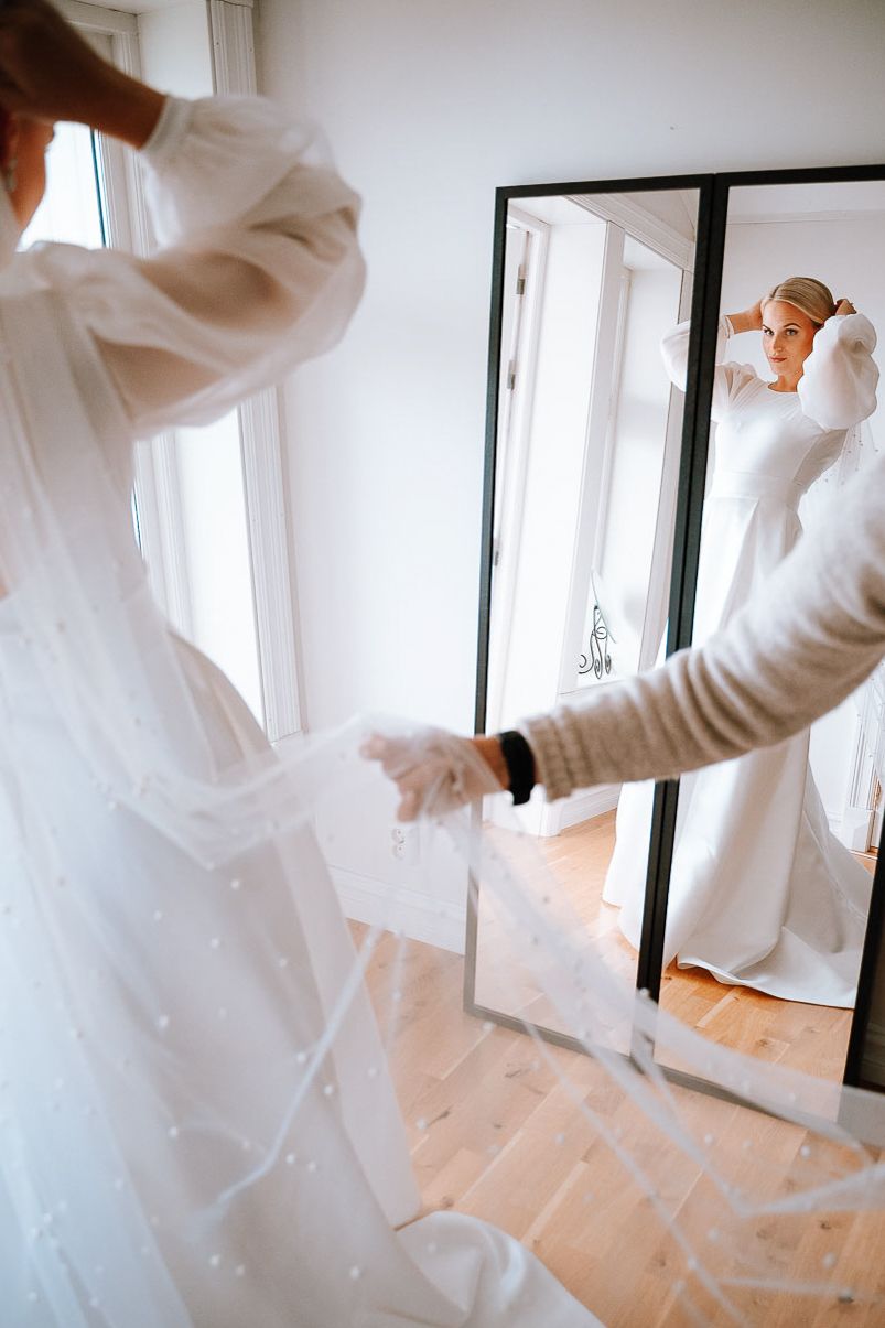 Ethereal white wedding dress fabric flowing in motion against a bright interior space.