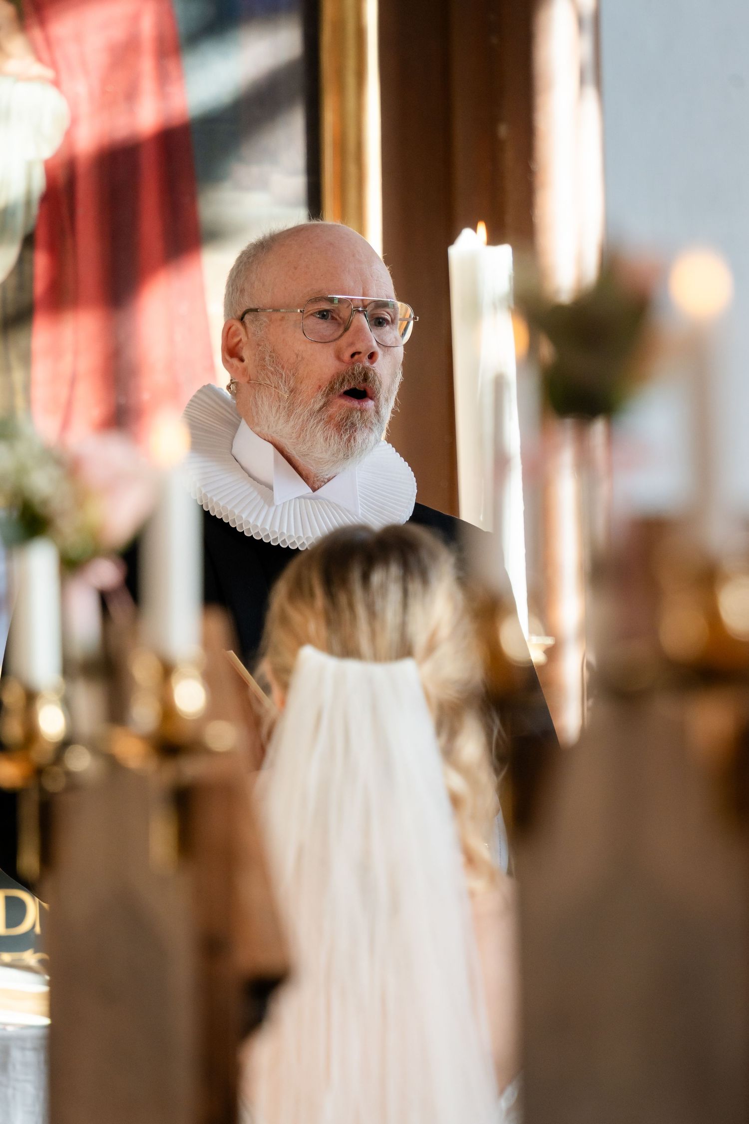 Religious officiant in traditional white collar and robe conducting a ceremony.