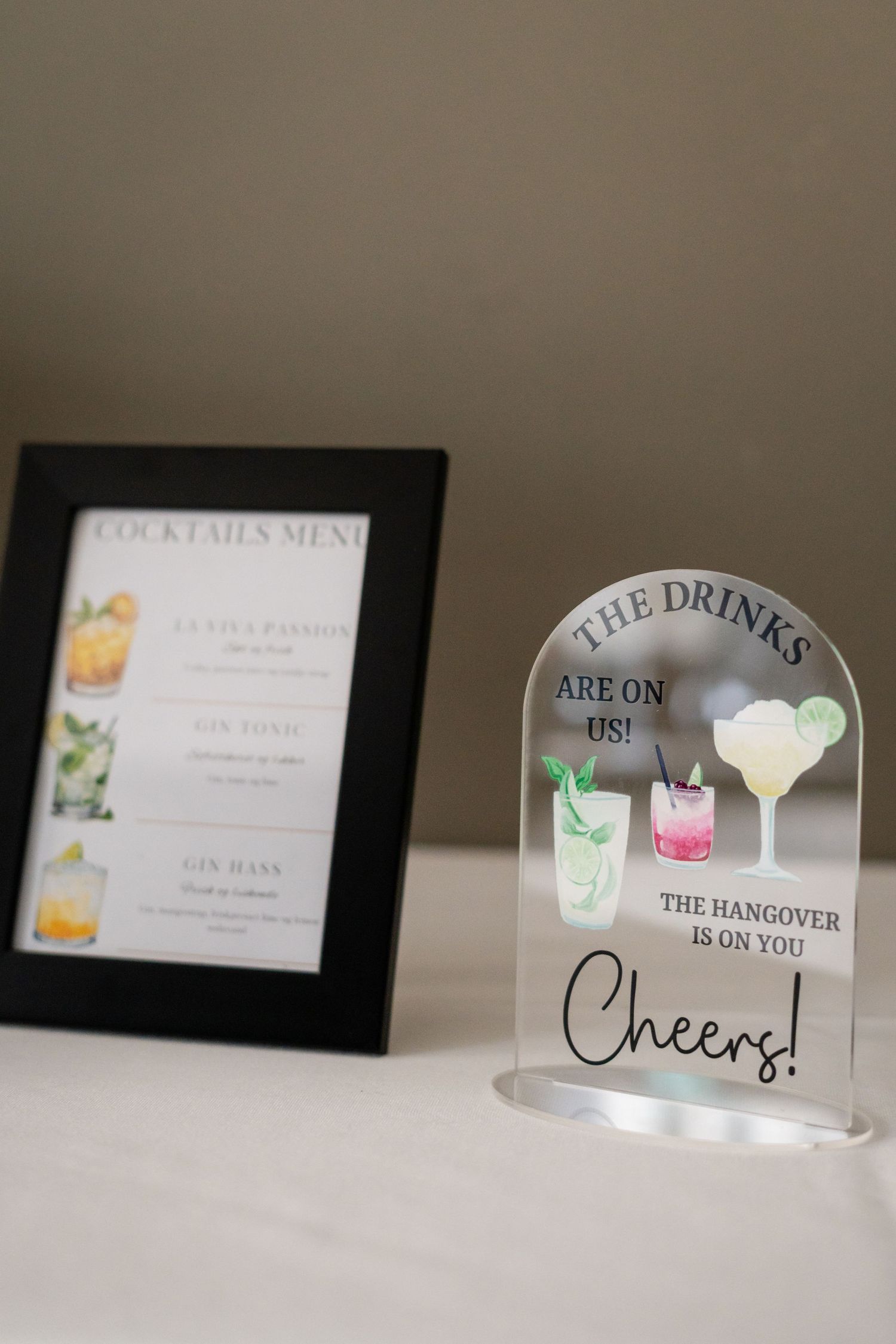 Wedding bar menu signs and cocktail displays arranged on a table.