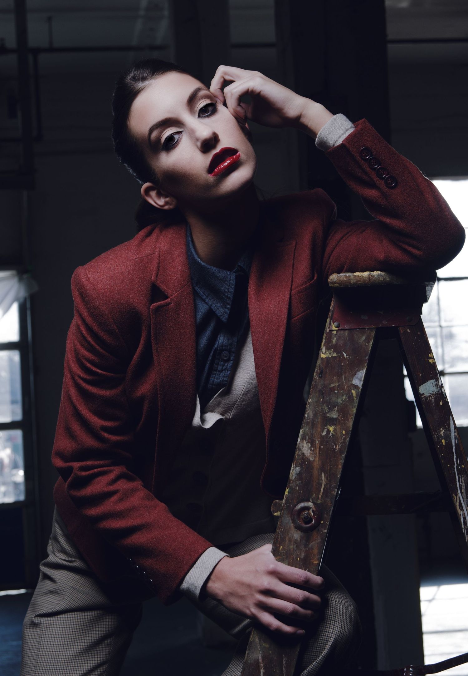 Fashion editorial series in dark lighting with burgundy blazer and dramatic poses.