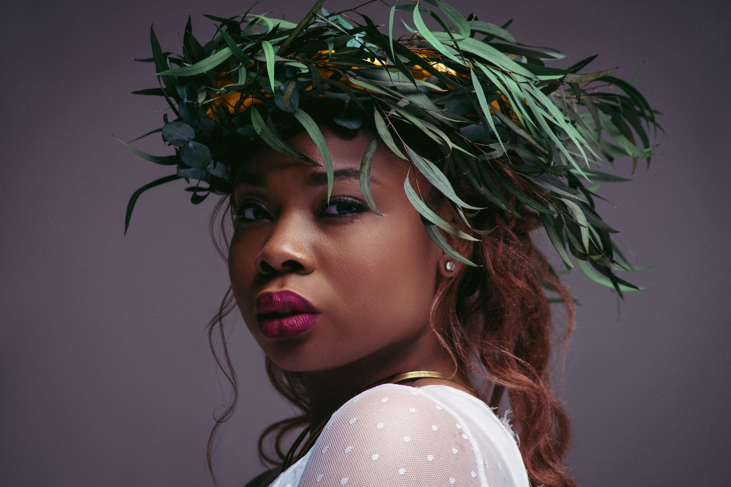 Artistic portrait series featuring green leaf crown against dark dramatic backdrop.