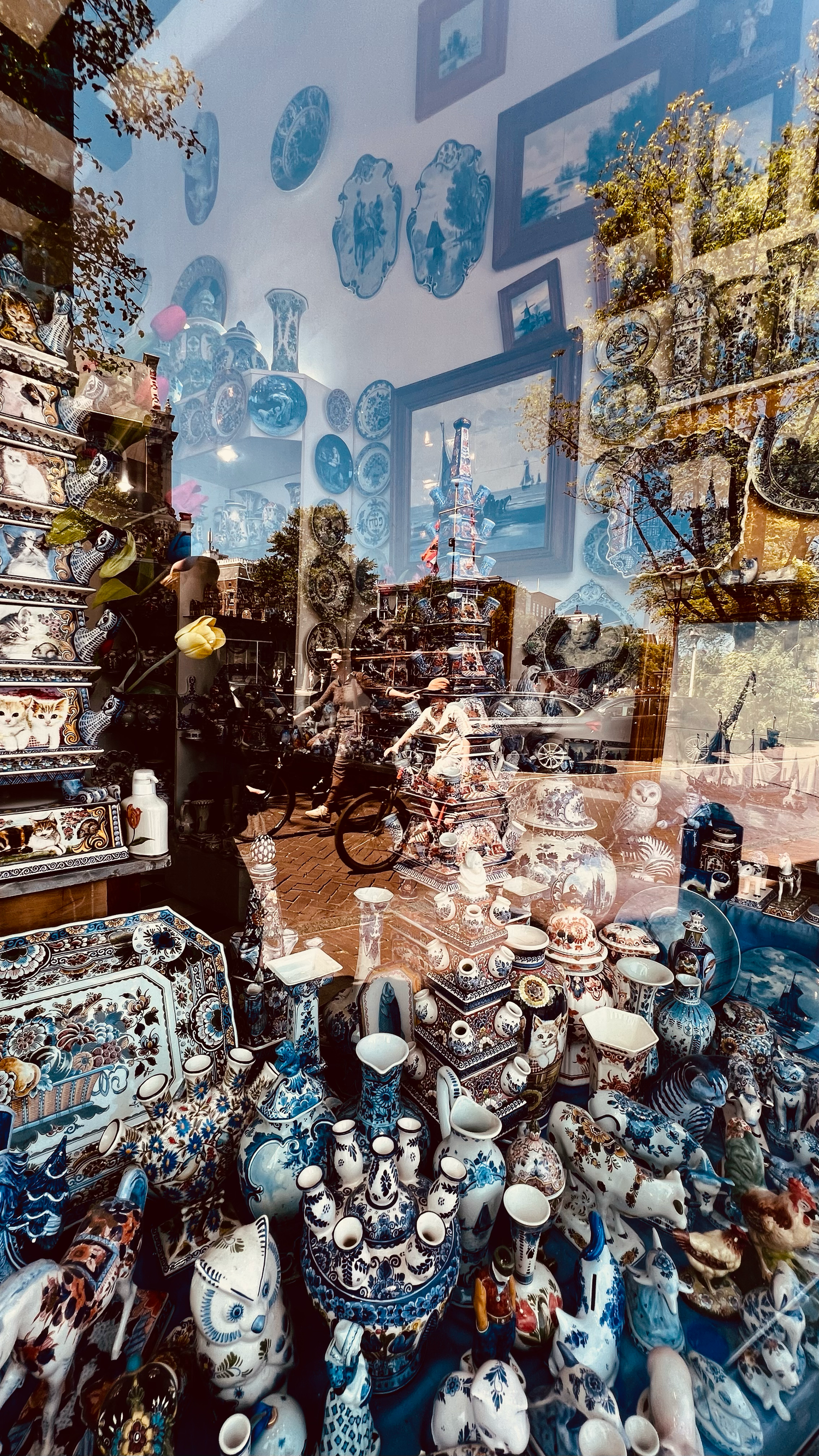 Antique shop window display filled with blue and white porcelain collectibles and decorative items.