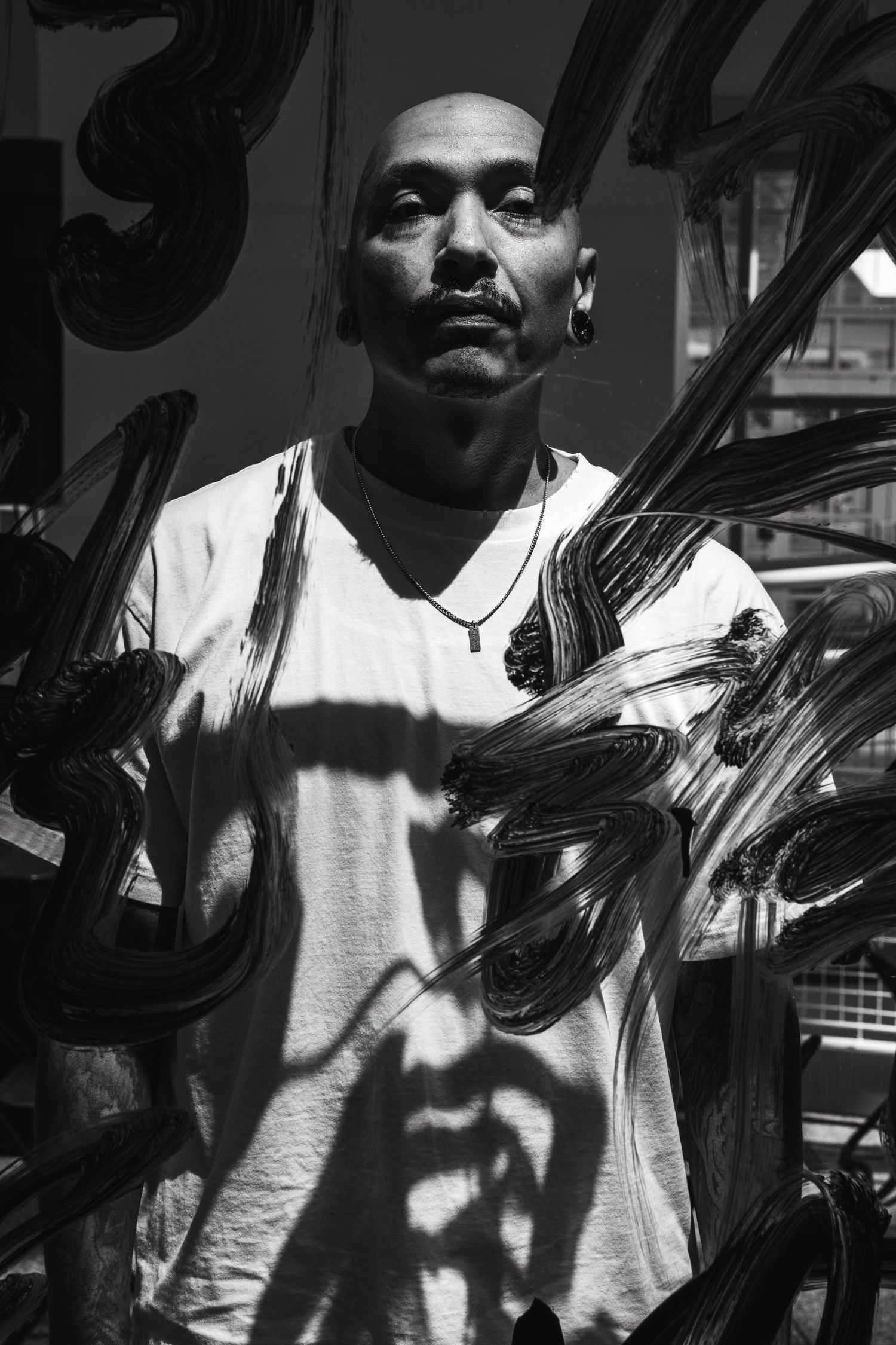 Black and white portrait series showing a person in a white t-shirt with dramatic shadows and lighting effects.