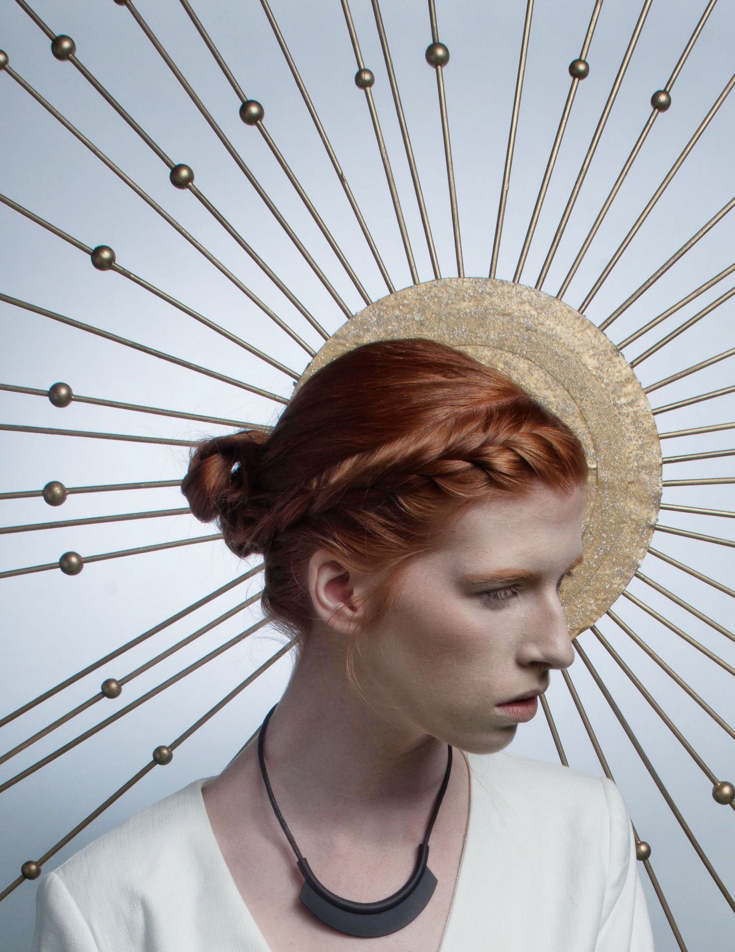 A figure wearing a gold metallic spiked halo headpiece against a white background shown in a sequence of profile views.