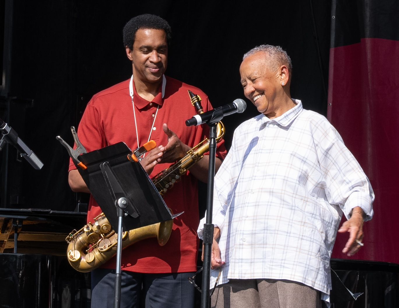 Nikki Giovanni and Musician performing together on stage with instruments at a jazz festival.