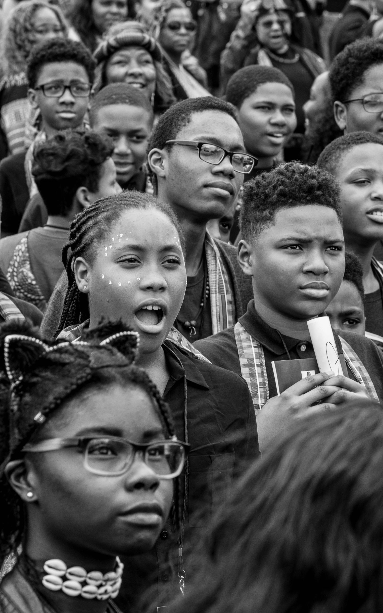 Black and white crowd photo showing engaged expressions during an important moment.