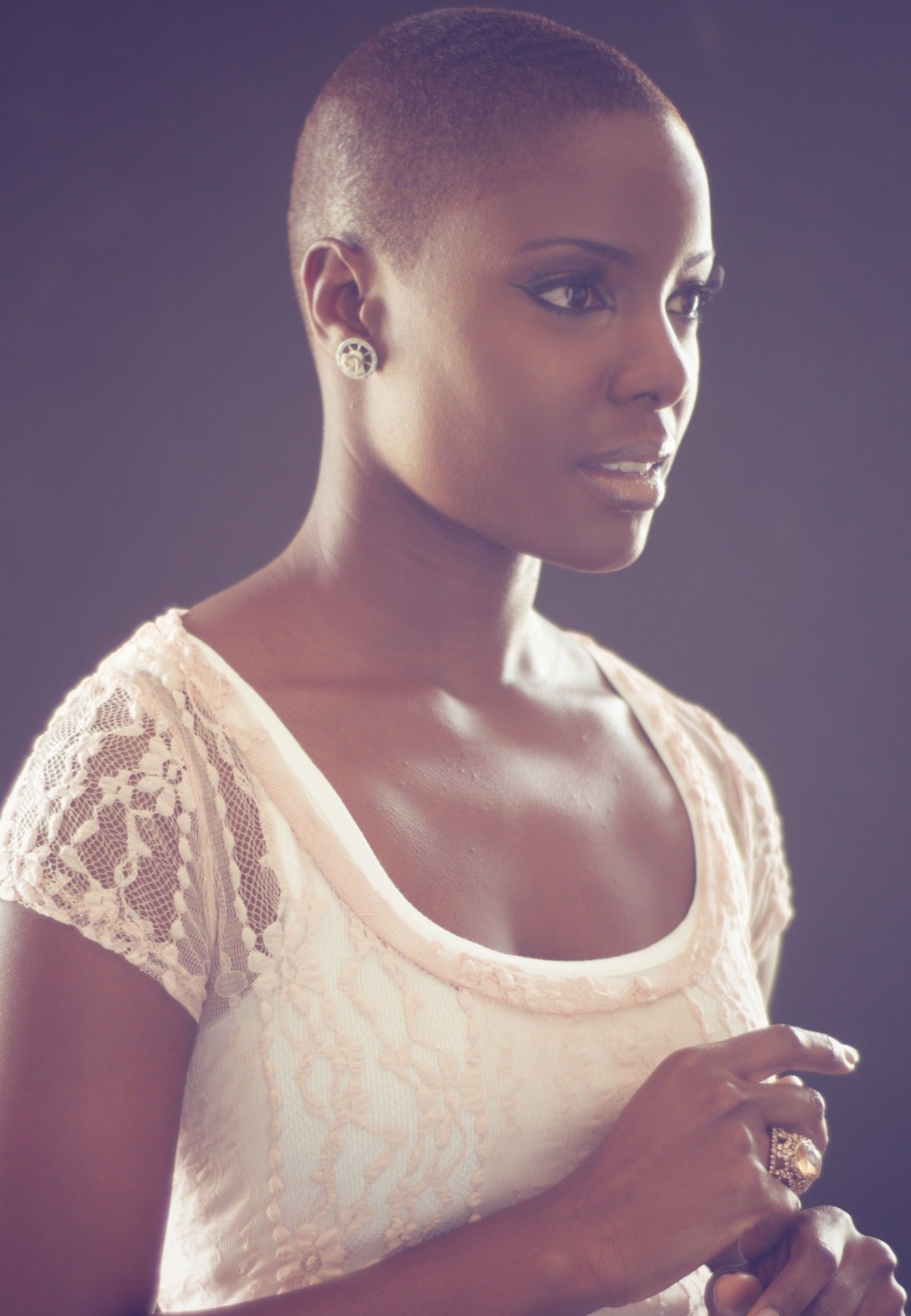 A person wearing a delicate white lace top is shown in a series of artistic profile portraits against a dark background.