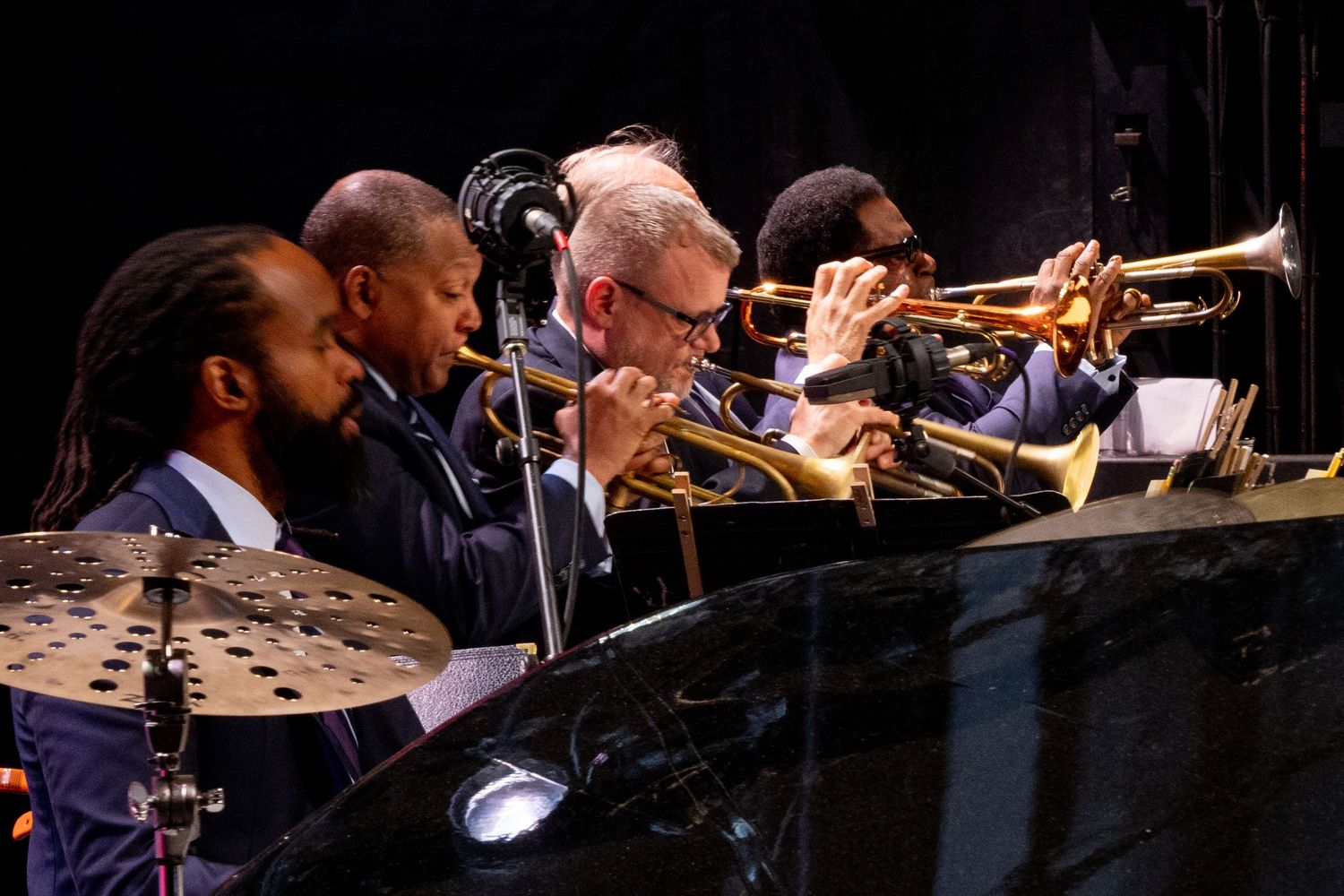 Jazz musicians playing trumpets and other brass instruments during a performance.