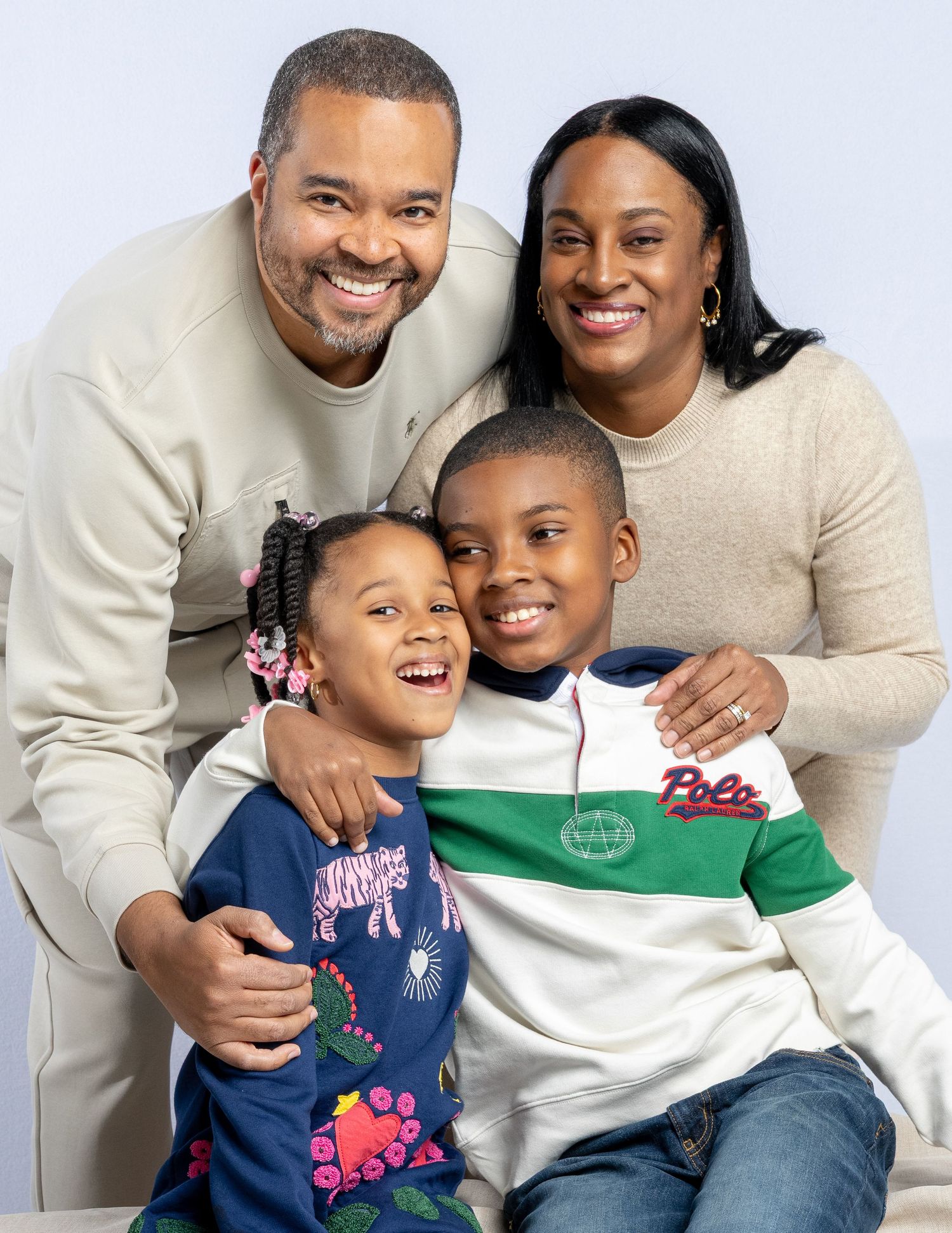 A family of four smiles together during a professional studio photoshoot for Family Matters series.
