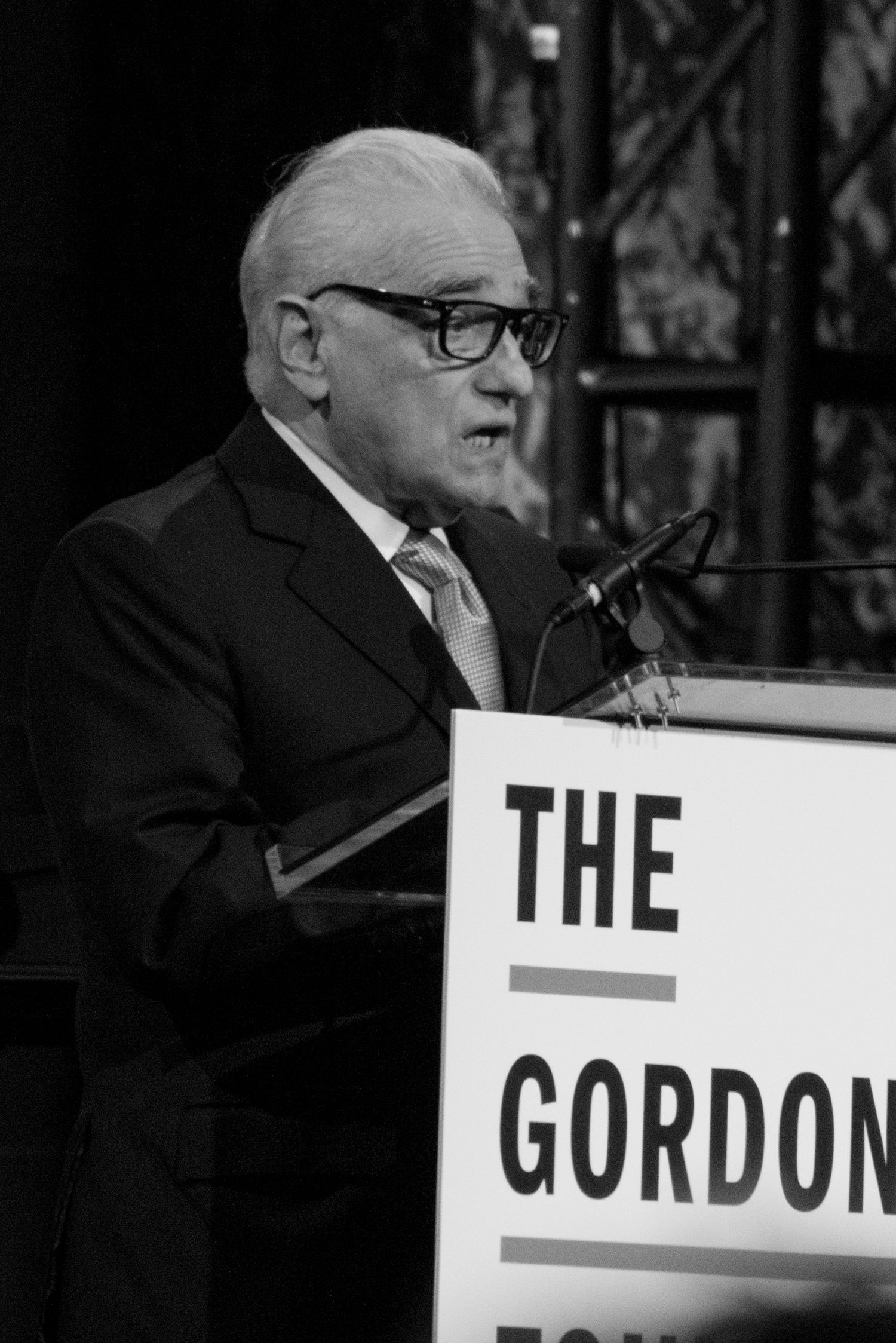 A sequence of black and white photos showing a sign being revealed letter by letter spelling out 'THE GORDON'.