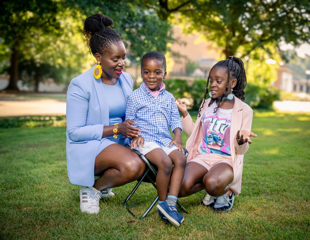 Family enjoying quality time together outdoors on a sunny day in a park setting.