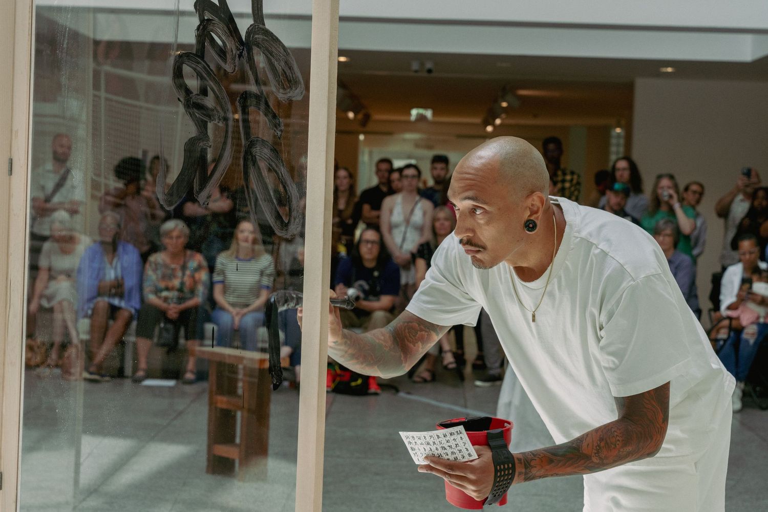 Spectators viewing an art performance in a modern museum setting.