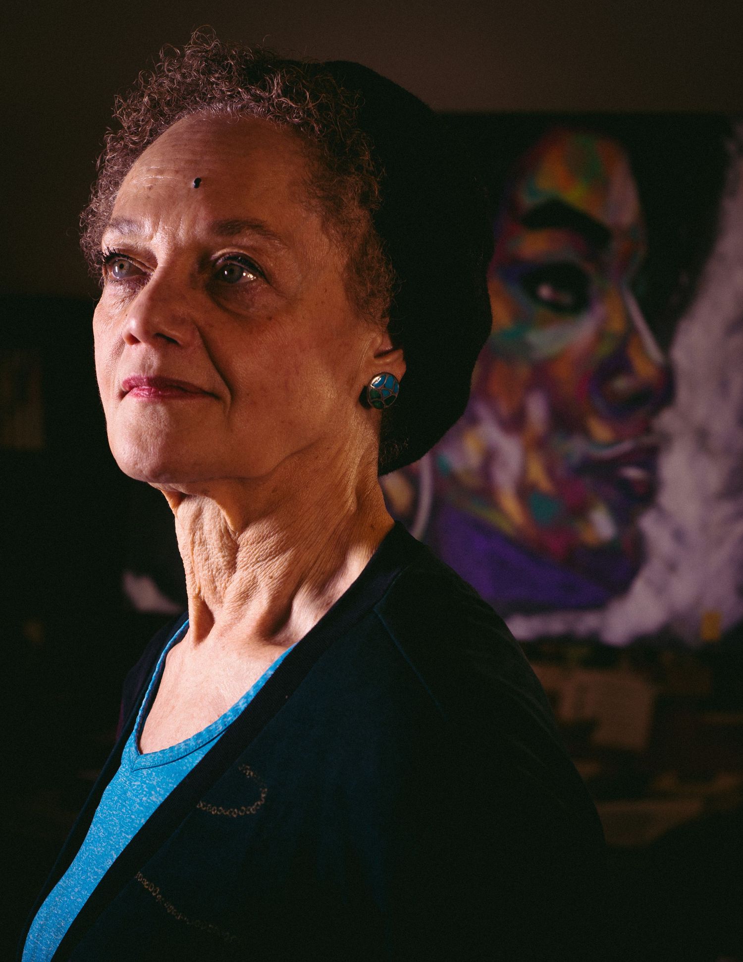 Dramatic side profile portraits in low light showing someone in a bright blue top.