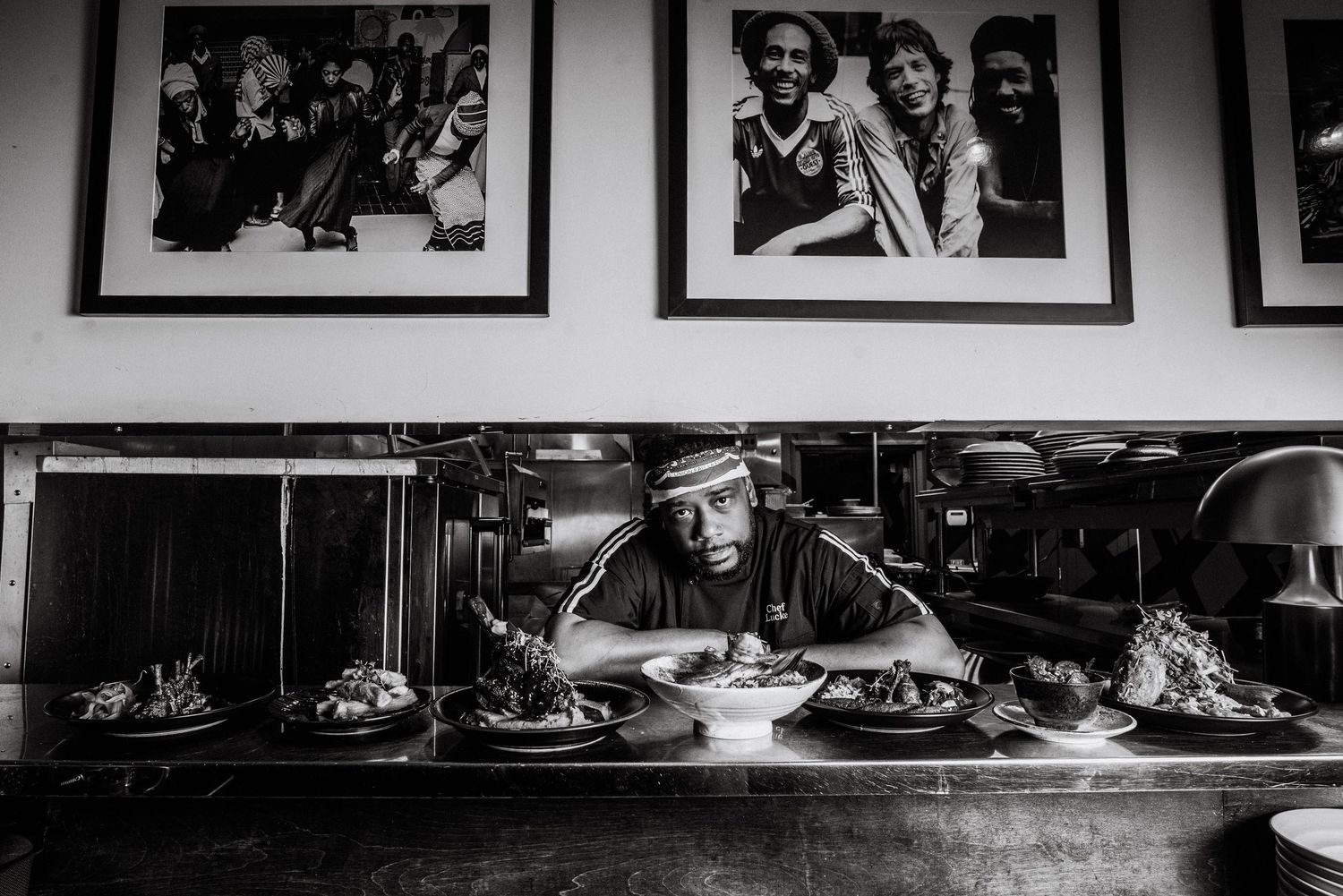 A black and white panoramic collage of framed photographs displayed on a wall showing various artistic compositions.