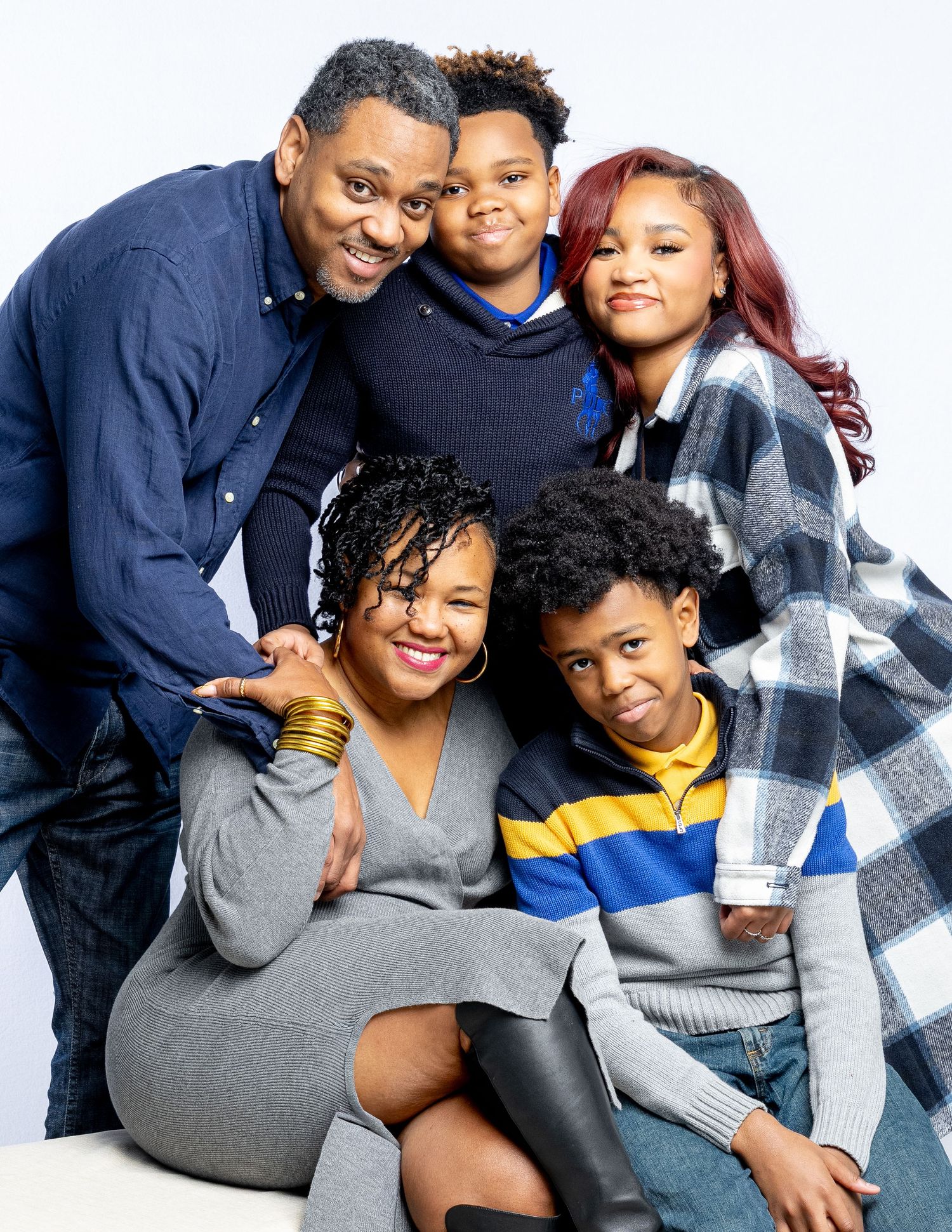 A family of five poses together for a studio portrait wearing casual clothing for Family Matters series.