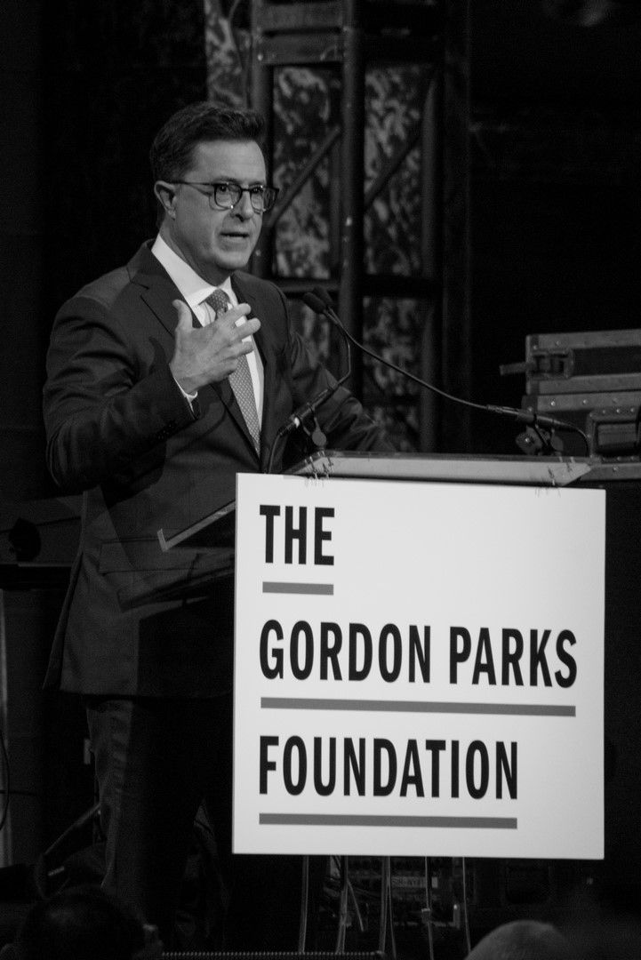 A black and white image shows a sign for 'THE GORDON PARKS FOUNDATION' on a display stand at an event.